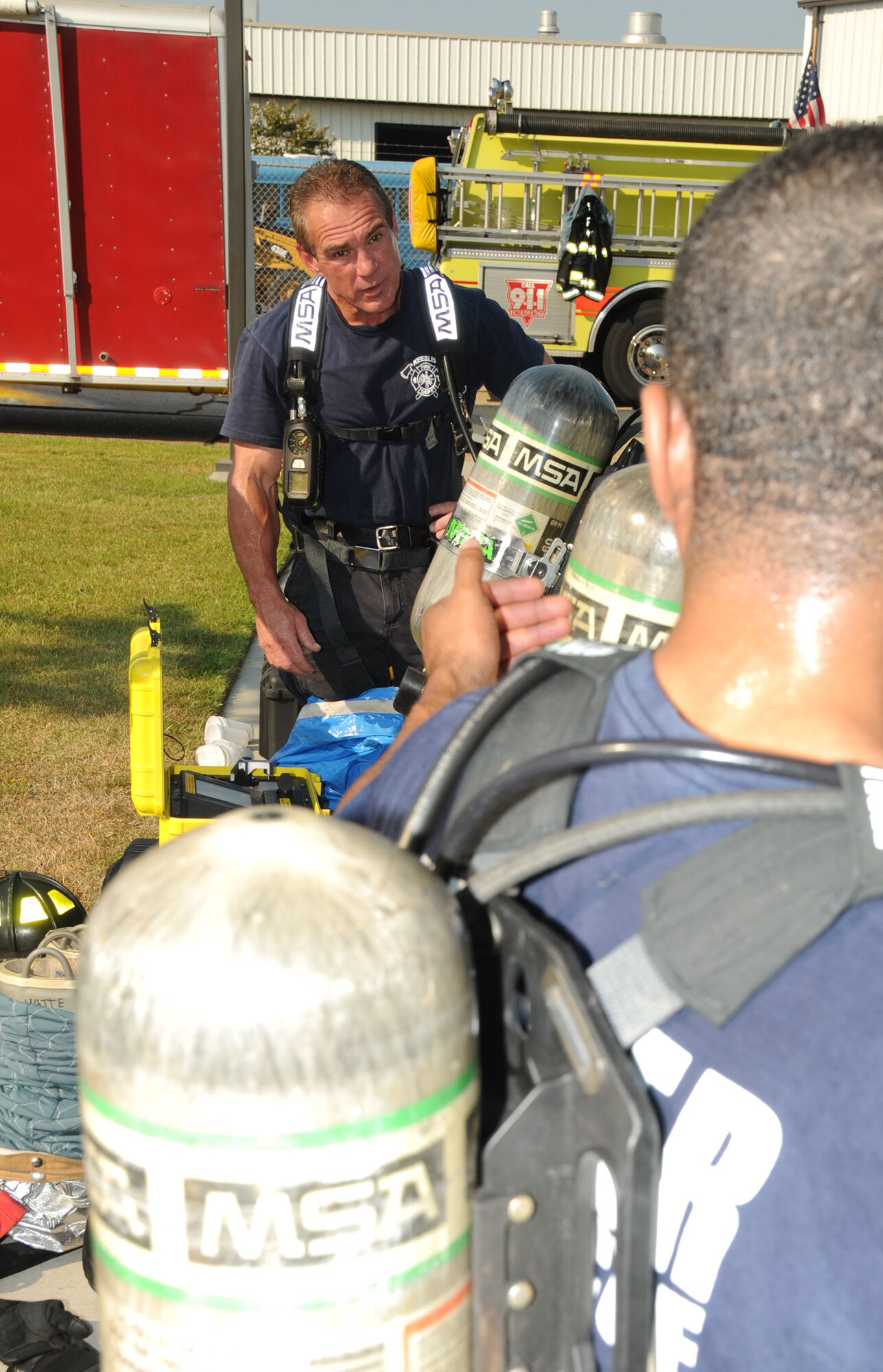 Firefighters Rusty Bell, left, and John McIntyre prepare to enter Matero Hall during a bioterrorism exercise Aug. 31.  In the scenario, a package was delivered containing a suspicious white power substance was delivered.  Two "victims" required medical treatment and 60 occupants of the building  were evacuated and underwent decontamination as a precaution.  (U.S. Air Force photo by Kemberly Groue)