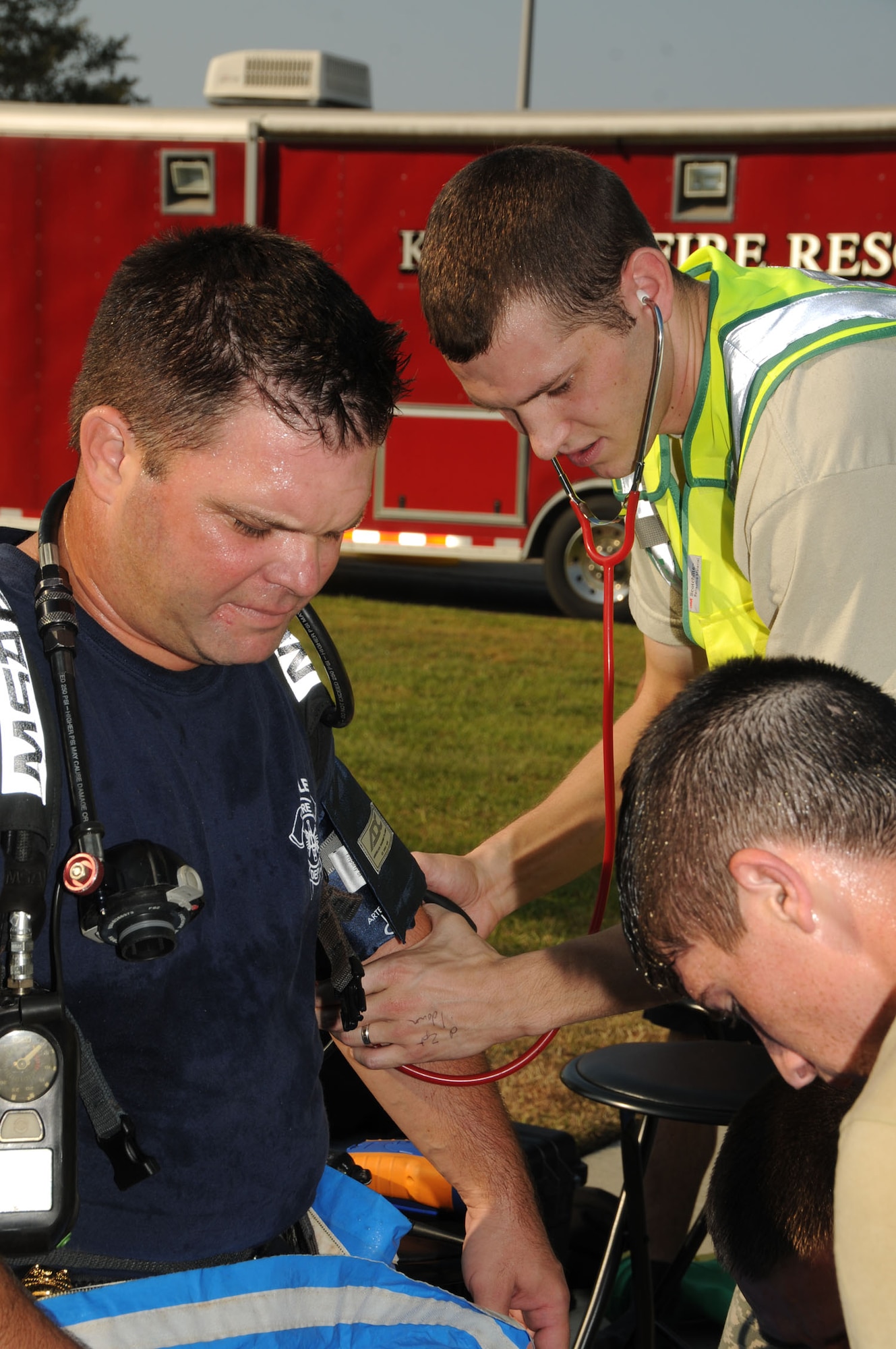 From left, firefighter Chad Martin has his vital signs checked by Senior Airman Joseph Lockman, 81st Medical Operations Squadron, as Senior Airman Aric Schneeberger, another firefighter, helps him put on his protective gear to prepare to enter Matero Hall during a bioterrorism exercise Aug. 31.  In the scenario, a package was delivered containing a suspicious white power substance was delivered.  Two "victims" required medical treatment and 60 occupants of the building  were evacuated and underwent decontamination as a precaution.  (U.S. Air Force photo by Kemberly Groue)
