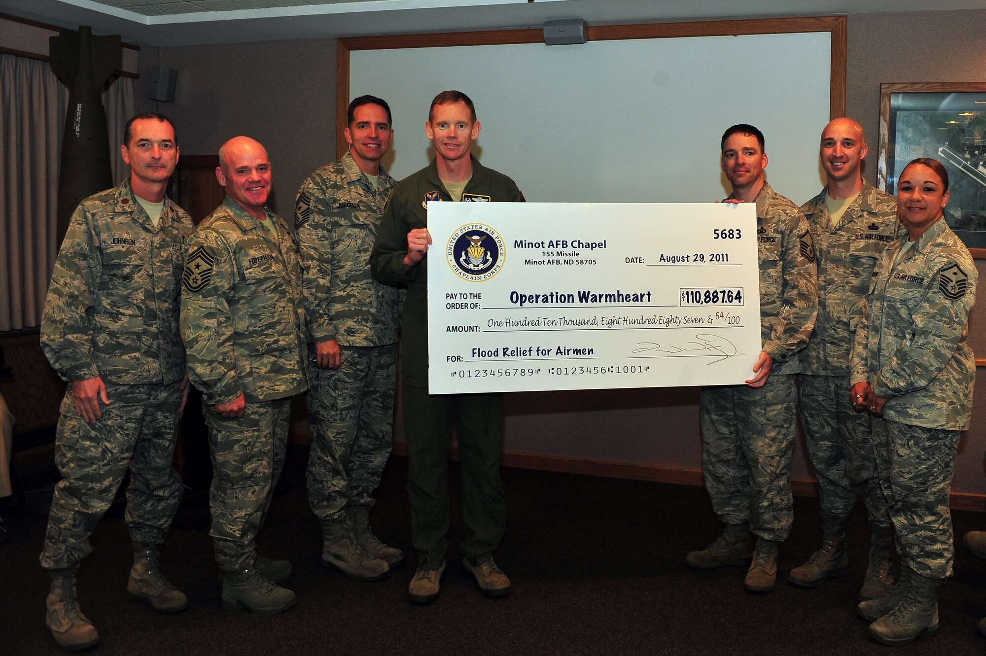 MINOT AIR FORCE BASE, N.D. -- Minot AFB chaplains recently presented a $110,887 check to Operation Warmheart’s Minot Flood relief on behalf of the Air Force Chaplain Corps. Base leadership praised the charitable contributions as a testament to the Air Force’s dedication in taking care of its family. In total, Operation Warmheart has received $197,000 in contributions from across the globe. Funds from donations are currently being used to help Airmen and their families with grants to help offset flood related expenses. More than $107,000 has been given to Team Minot Airmen in need. (U.S. Air Force Photo/Senior Airman Jesse Lopez)