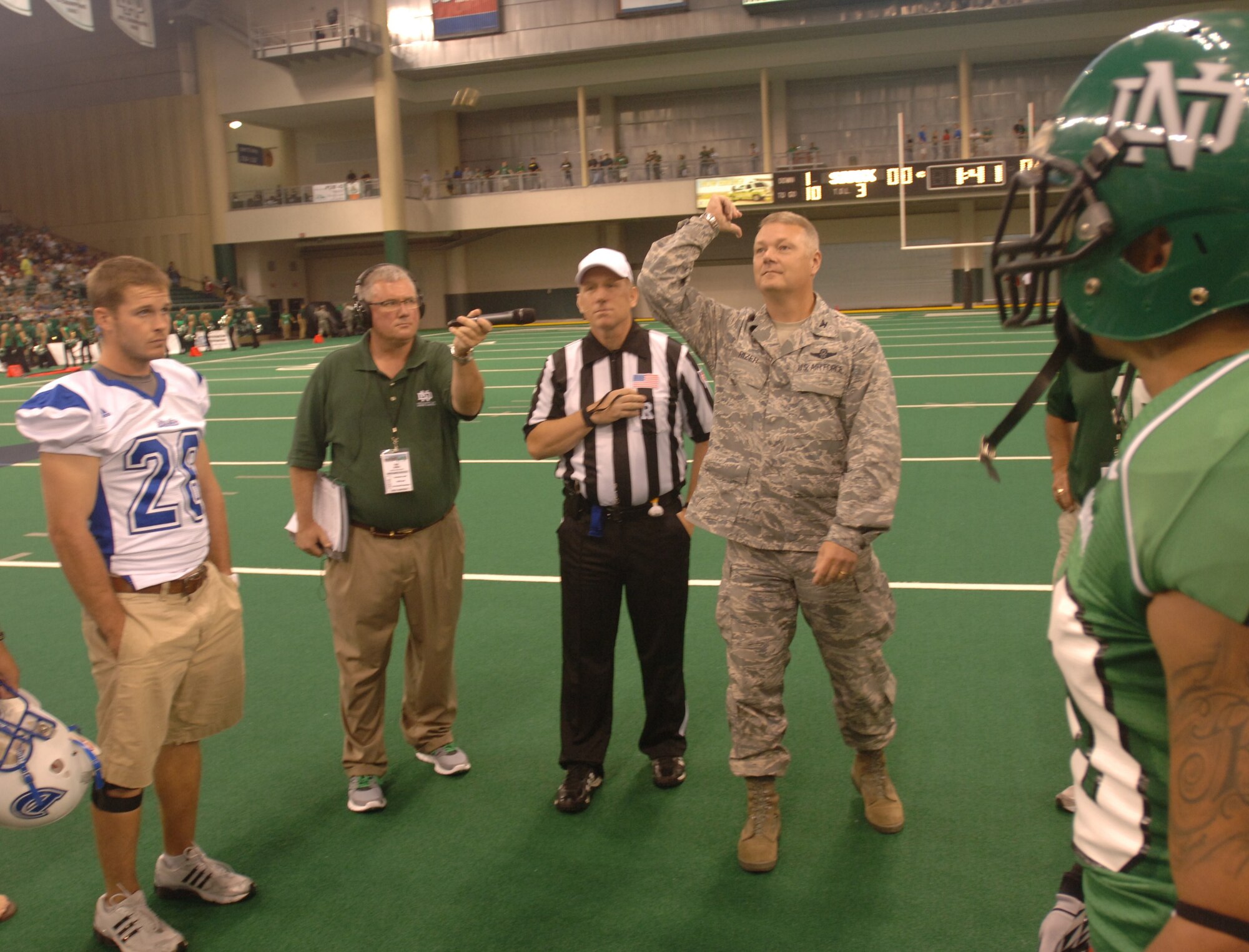 Col. Scott Rizer, 319th Air Base Wing vice commander, tosses the coin before a Sept. 1 football game between the University of North Dakota and Drake University. Hundreds of servicemembers and their family members were invited to attend the game for free as part of UND’s 14th Annual Maury Rothkopf Military Appreciation Day. (U.S. Air Force photo/Tim Flack)