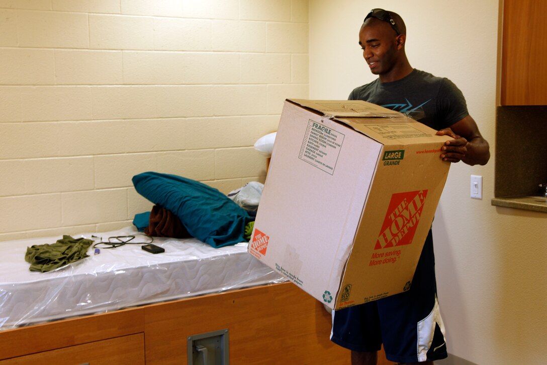 Lance Cpl. James E. Harris, intelligence specialist, 15th Marine Expeditionary Unit, moves in to his new barracks, building 2160 on Camp Del Mar, September 7. Marines and sailors of the 11th, 13th and 15th Marine Expeditionary Units along with I Marine Headquarters Group personnel, moved into the new state-of-the-art barracks in order to improve quality of life.