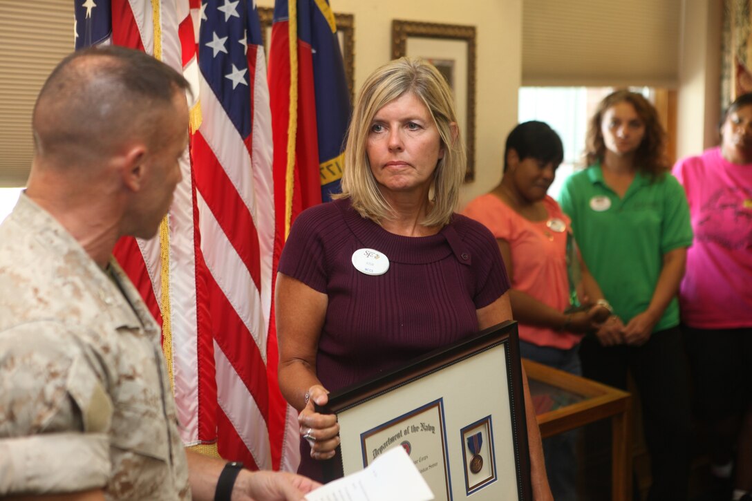 Col. Daniel J. Lecce, the Marine Corps Base Camp Lejeune commanding officer, reads a letter, written to the MCB Camp Lejeune commanding officer, to Josie Martin from the mother of a swimmer Martin rescued Sept. 9 at Lejeune Hall aboard the base. Martin revived a 14-year-old boy after he passed out and fell in the deep end of the Area 2 Pool July 6 aboard the base. Martin received the commendation for meritorious civilian service for her lifesaving efforts.