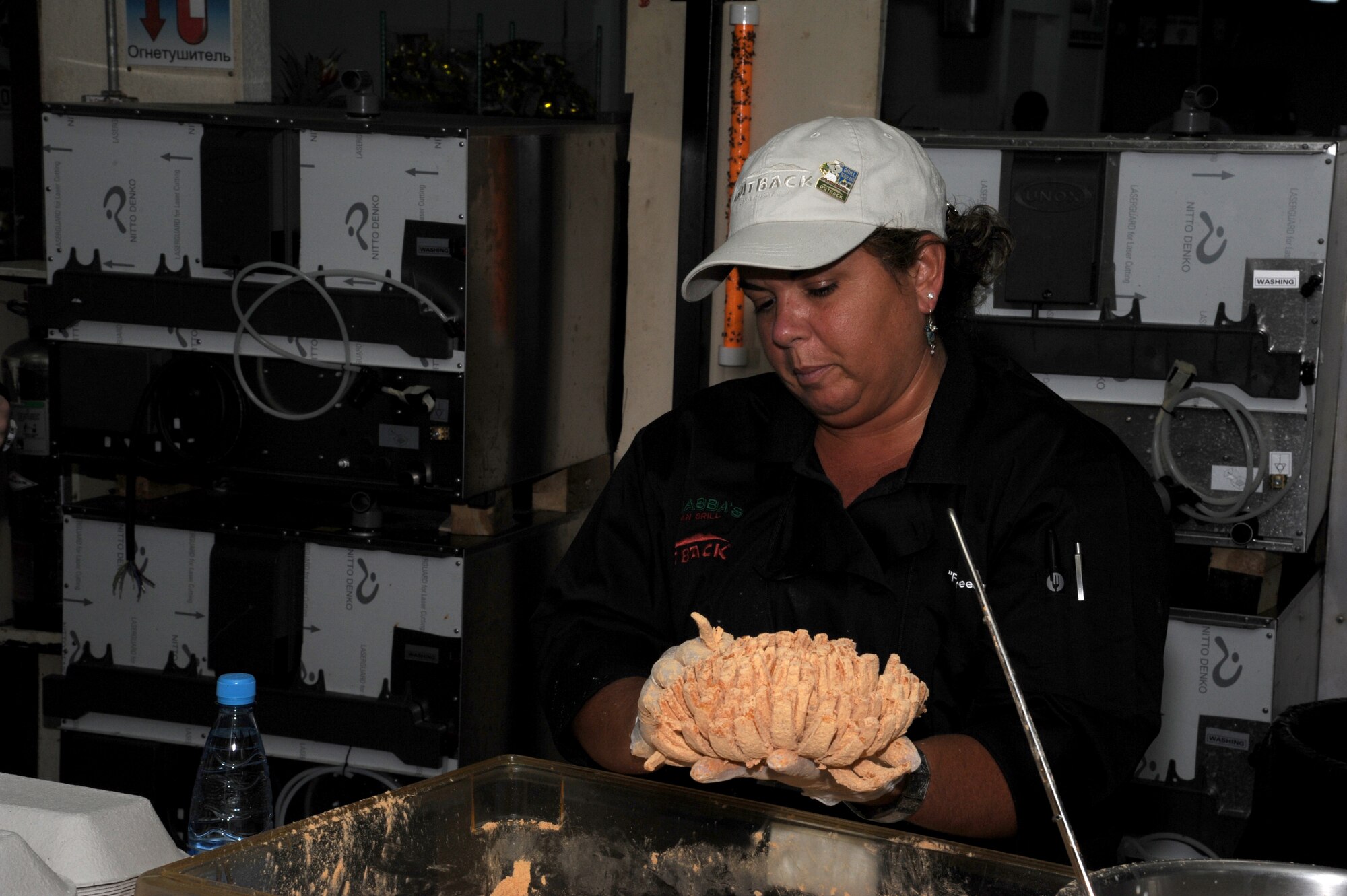 Sherri Rutolo, Outback Steakhouse Inc. employee, prepares a Bloomin’ Onion, Outback’s signature appetizer, at the main dining facility at the Transit Center at Manas, Kyrgyzstan, Sept. 5. In addition to the signature dish, patrons selected from three types of pasta and ribeye steaks. Outback Steakhouse is part of OSI Restaurant Partners, LLC, which also includes Bonefish Grill, Carrabba's Italian Grill, Fleming's Prime Steakhouse & Wine Bar, and Roy’s Hawaiian Fusion Cuisine. Employees from across the chain competed for the chance to serve troops in deployed locations as part of their Operation Feeding Freedom IX tour. (U.S. Air Force photo/Tech. Sgt. Hank Hoegen)  