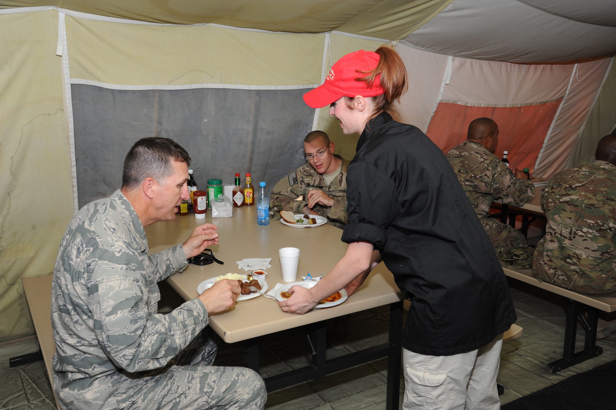 Jessica Pivetta, Outback Steakhouse Inc. employee, serves food to anxiously awaiting service members at Colonel Mac's dining facility as part of Operation Feeding Freedom IX at the Transit Center at Manas, Kyrgyzstan, Sept. 5. Employees volunteered and competed for the chance to serve troops in deployed locations as part of their Operation Feeding Freedom IX tour. One Sailor’s Facebook post exclaims “OUTBACK RULES ... I am on my way home from 6+ months in Afghanistan and OUTBACK is sponsoring our dinner out here in MANAS!!!! BRAVO OUTBACK!!!!” (U.S. Air Force photo/Tech. Sgt. Hank Hoegen)  