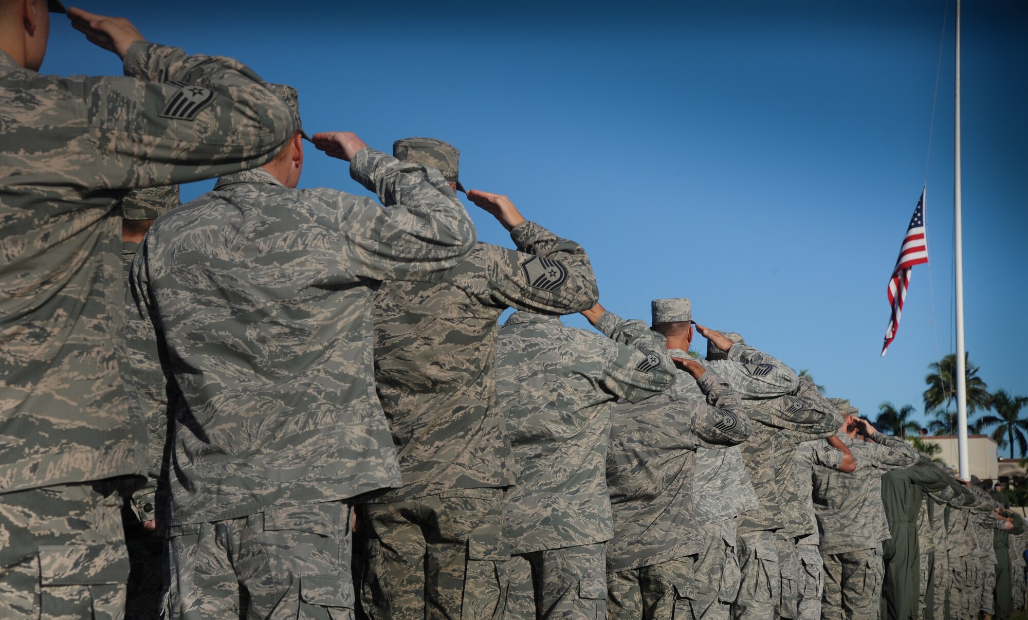 Airmen from Joint Base Pearl Harbor-Hickam, Hawaii, salute as the honor guard raises the flag during a Sept. 11 remembrance ceremony at Atterbury Circle here, Sept. 9. The ceremony commemorated the lives lost during the attacks on Sept. 11, 2001, and all those who have served to protect freedom in the Global War on Terror since that day. (U.S. Air Force photo/Senior Airman Lauren Main)