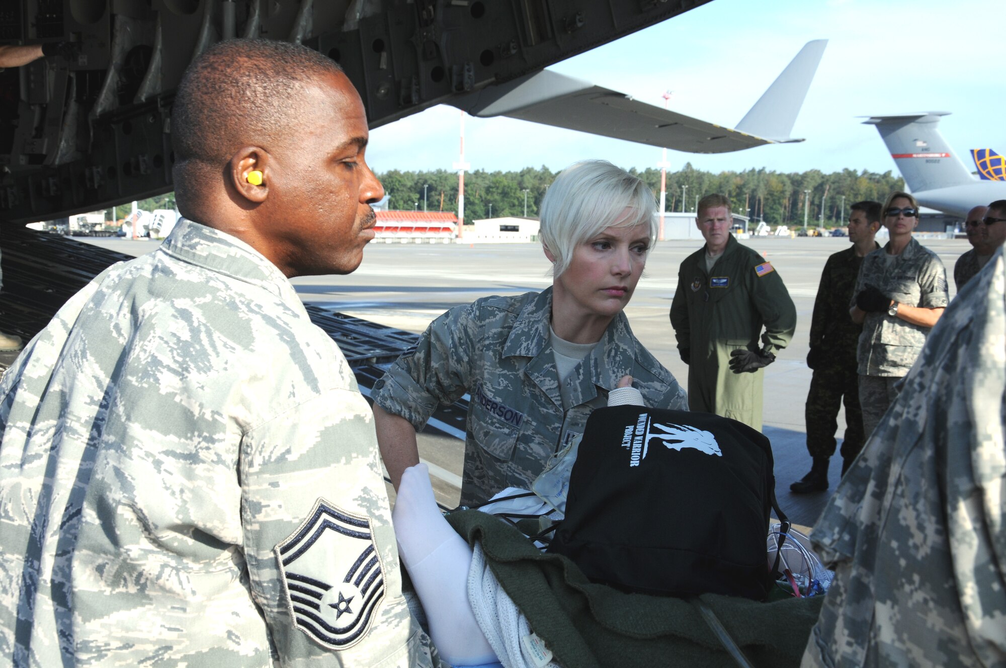 Master Sgt. Michelle Anderson, (center) a medical administrator with 446th Aeromedical Staging Squadron, Joint Base Lewis-McChord, Wash., transports a patient from a C-17 Globemaster III to an ambulance on the Ramstein Air Base, Germany flightline Aug. 24. The patients arrived in Ramstein from Bagram AB in Afghanistan. Anderson is on a three-month deployment to Ramstein as part of Operation Enduring Freedom. (U.S. Air Force photo by 2nd Lt. Denise Hauser)