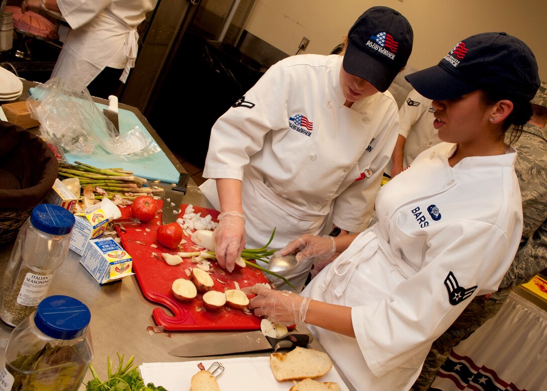 Airmen 1st Class Brittany Edgmon and Alexandria Barse, 28th Force Support Squadron food services apprentices, discuss what direction they’re going with their hollowed potatoes during the Ellsworth Iron Chef competition at the Bandit Inn dining facility, Ellsworth Air Force Base, S.D., Aug. 26, 2011. The one-hour competition pitted three teams against each other and challenged participants to use all food items provided to include a “secret ingredient,” raspberries. (U.S. Air Force photo/Tech. Sgt. Jerry Fleshman/Released)