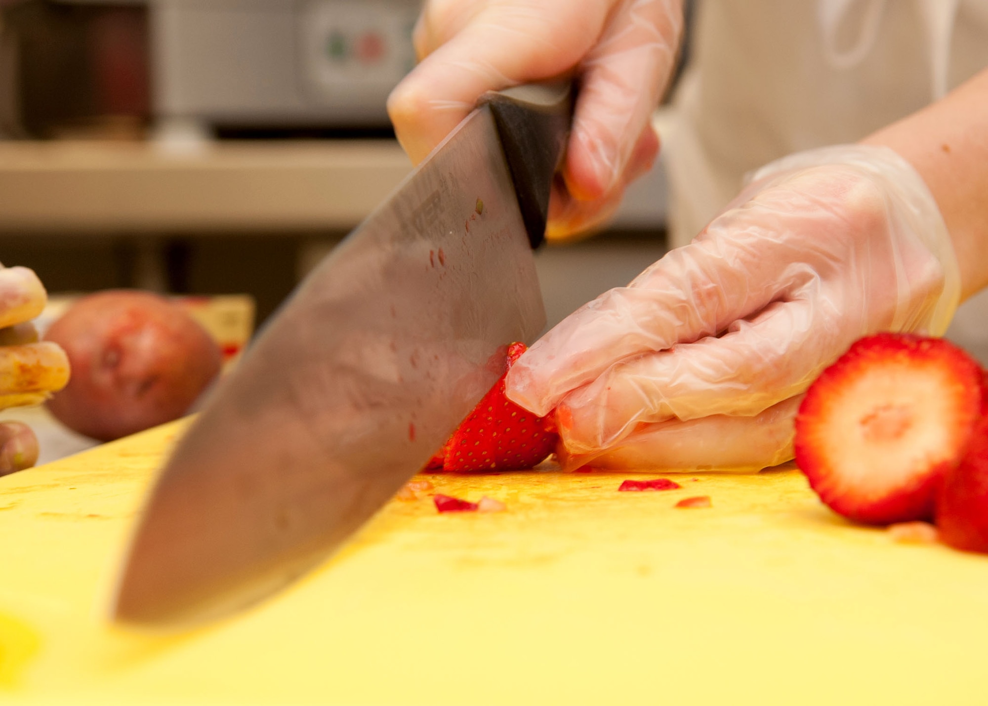 Airman 1st Class Nichole Pierce, 28th Force Support Squadron food services apprentice, slices fresh strawberries during the Ellsworth Iron Chef competition at the Bandit Inn dining facility, Ellsworth Air Force Base, S.D., Aug. 26, 2011. The one-hour competition pitted three teams against each other and challenged participants to use all food items provided to include a “secret ingredient.” (U.S. Air Force photo/Tech. Sgt. Jerry Fleshman/Released)