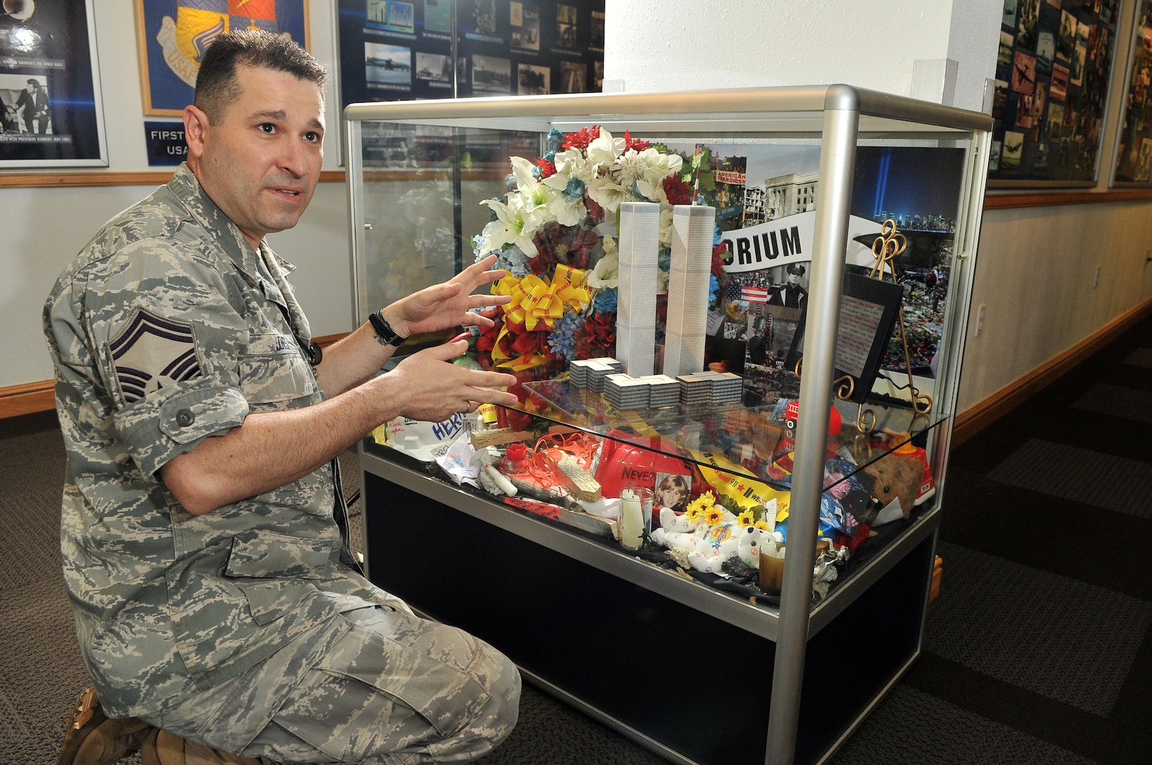 Senior Master Sgt. Benjamin Jones of the Air Force Intelligence,Surveillance and Reconnaissance Agency History Office, describes on Sept. 9 how he designed the 9/11 display case honoring the victims of the World Trade Center twin towers. (Photo by William Belcher)
