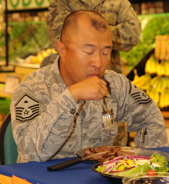 LAUGHLIN AIR FORCE BASE, Texas – Master Sgt. James Escher, 47th Mission Support Group first sergeant, competes in a steak-eating contest at Laughlin’s commissary Sept. 9. Escher, Chief Master Sgt. Dean Ferris, 47th Operations Group superintendent; Chief Master Sgt. Russell Thomas, 47th Medical Group superintendent and Master Sgt. Nick Kurpier, 47th Security Forces Squadron first sergeant, were all tasked to eat a 47-ounce steak and a salad. All participants were given commissary gift certificates meant to be used to purchase food to donate to the “Feds Feed Families” food drive. (U.S. Air Force photo by Airman 1st Class Blake Mize) 
