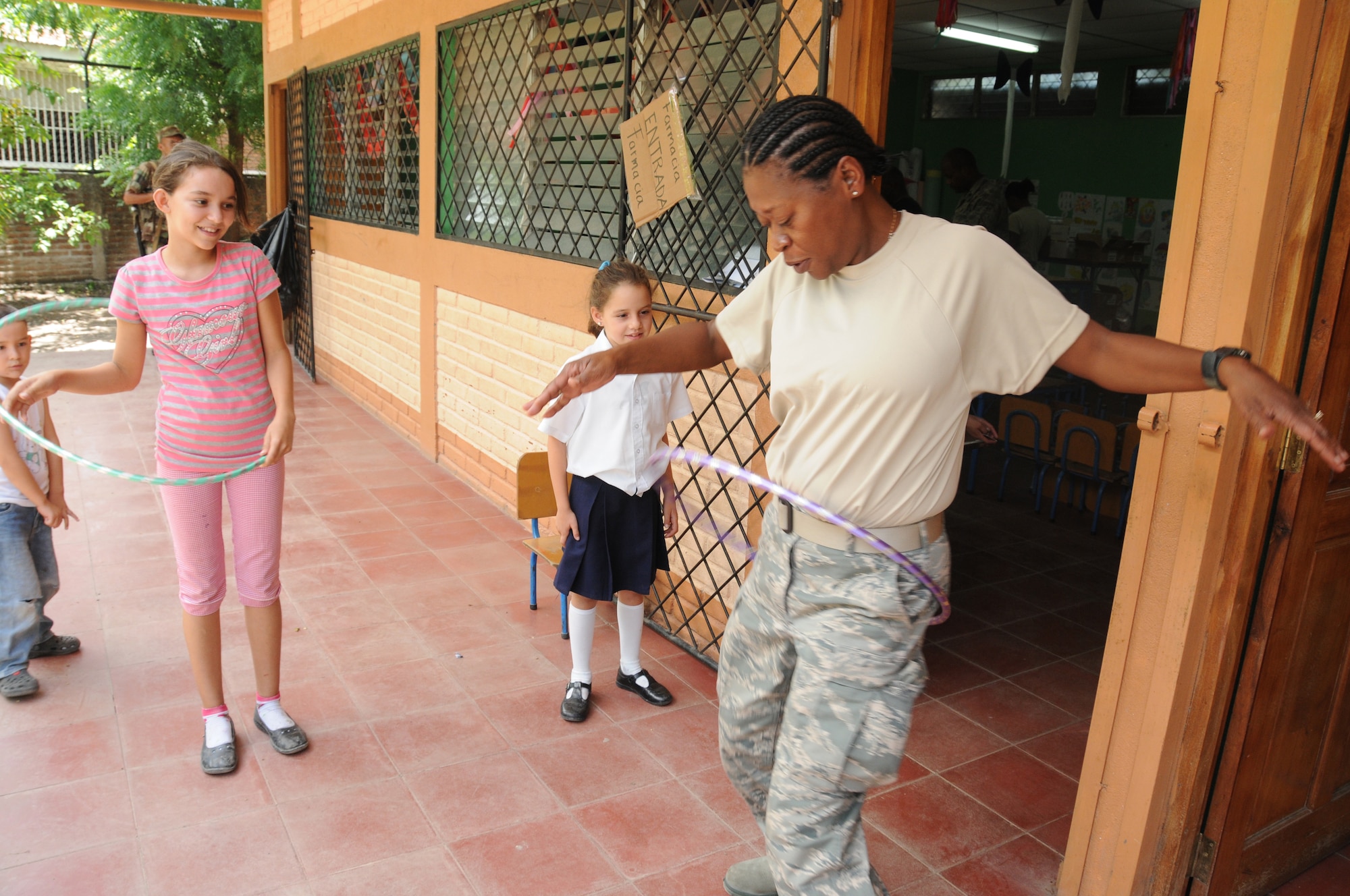 Master Sgt. Julia McKenzie, first sergeant for the 916th Aerospace Medicine Squadron in North Carolina, demonstrates proper hula-hooping technique to some local children here Aug. 8, 2011. McKenzie led an effort to collect hundreds of donated toys that were given to young patients here during the unit’s Medical Readiness Training Exercise, or MEDRETE. (USAF photo by Senior Airman Meredith A. H. Thomas, 916 ARW/PA)