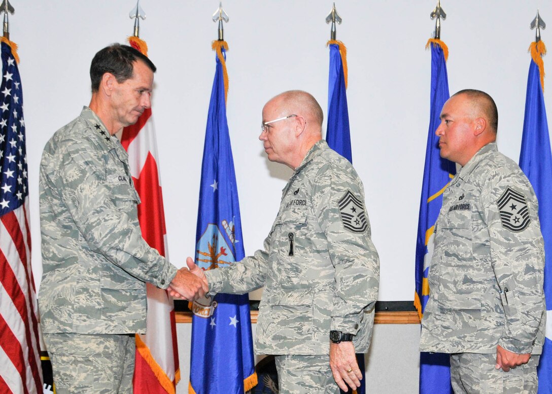 Chief Master Sgt. Joseph Thornell (center), Air Forces Northern command chief, passes his coin to Lt. Gen. Sid Clarke Sept. 8 as Chief Master Sgt. Mitchell Brush watches on and prepares to accept the coin from Clarke, symbolizing his assumption of responsibility of the command’s enlisted force. Thornell came on board as AFNORTH command chief in December 2009 and is transferring to Fresno, Calif., where he will serve as the command chief of the 144th Fighter Wing. (U.S. Air Force photo by Susan Trahan)