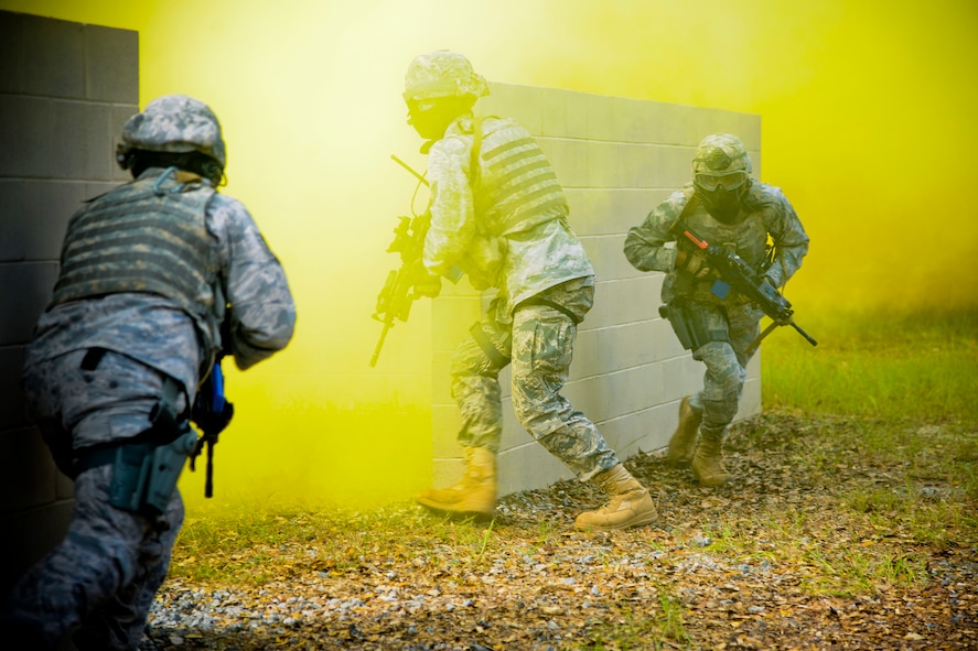 U.S. Air Force members of the 823rd Base Defense Squadron (BDS) throw smoke and charge into a building during a demonstration at Moody Air Force Base, Ga., Sept. 8, 2011. Smoke was used to conceal their movements during the demonstration. When training, the 823rd BDS mimics situations typically seen when deployed to stay proficient in tactics and maneuvers. (U.S. Air Force photo by Airman 1st Class Paul Francis/Released)
