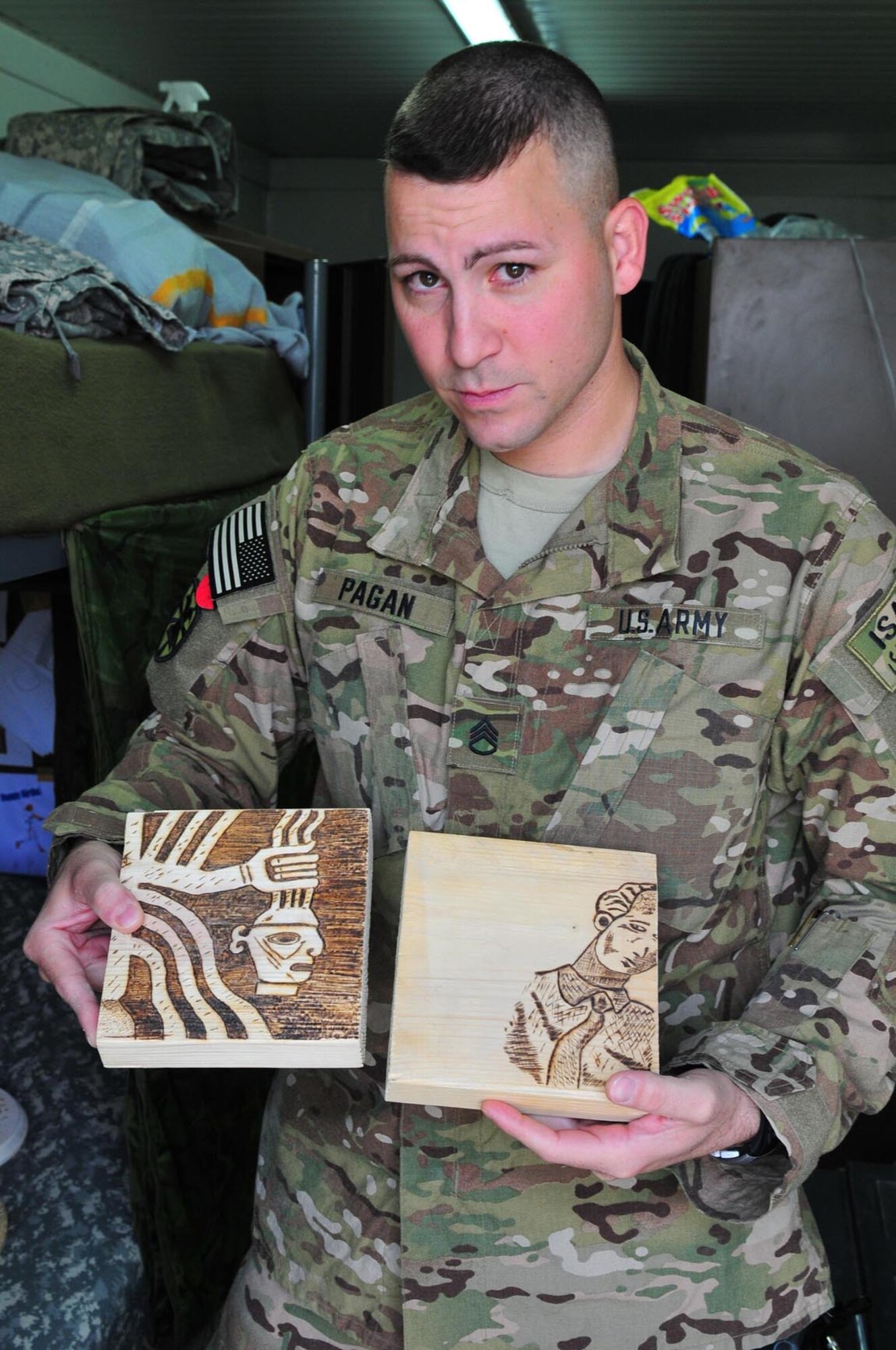 Staff Sgt. Omar Pagan, battle operations NCO with Task Force Resolute, 7th Sustainment Brigade, shows some of his pyrography. Pagan is currently deployed to Kandahar Airfield, Afghanistan. (US Army photo by Sgt. Edwin  Rodriguez/Released)