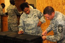 Members of the 567th REDHORSE Squadron secure several locks onto the case of an M-16 rifle issued here Aug. 31, 2011, prior to the unit's deployment.  The 567th RHS Airmen are scheduled to spend time training in Texas before deploying to various locations in the Middle East. (USAF photo by Senior Airman Meredith A. H. Thomas, 916 ARW/PA)