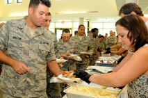 Volunteers serve a homemade barbecue lunch to deploying members of the 567th REDHORSE squadron, their families and other special guests.  The 567th RHS Airmen are slated to deploy to various locations in the Middle East. (USAF photo by Senior Airman Meredith A. H. Thomas, 916 ARW/PA)