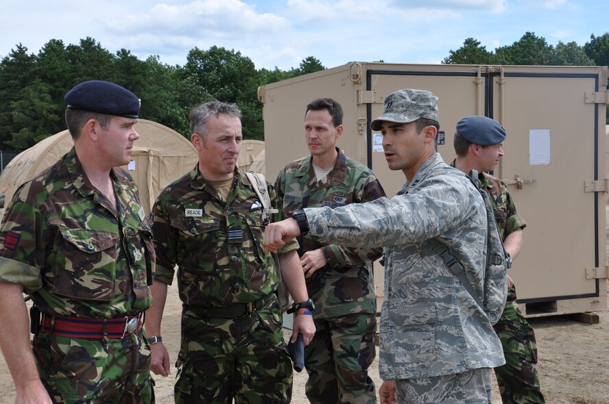 Capt. Robert Arnett, operations officer for the 571st Global Mobility Readiness Squadron of Travis Air Force Base, Calif., explains the mission and capabilities of his unit to Chief Warrant Officer Warren Iveson and Squadron Leader Simon Reade of the Bristish Royal Air Force, along with U.S. Air Force Maj Matt Gibson, the Foreign Exchange Officer for the RAF. The 571st CRG took part in an Eagle Flag exercise run by the U.S. Air Force Expeditionary Center Aug 21-27. (US Air Force photo by 1st Lt. Sybil Taunton/Released)