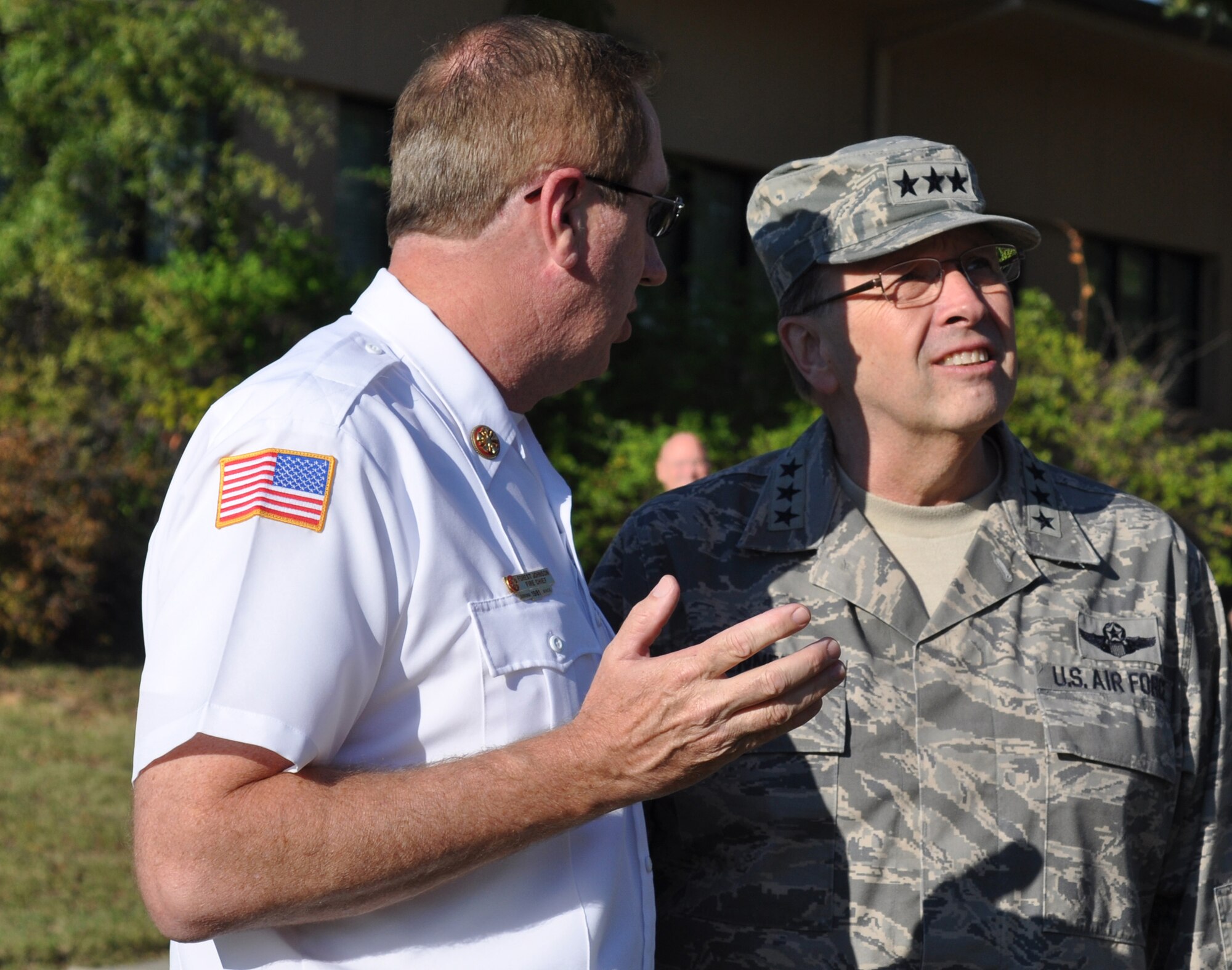 Lt. Gen. Charles E. Stenner, Jr., commander Air Force Reserve Command, listens as Forest Johnson, Robins Air Force Base fire chief, points out the placement of the 9/11 stone on the ladder truck for the commemoration procession from the AFRC headquarters building to the Museum of Aviation. The stone, an artifact from the 9/11 attack on the Pentagon, is a symbol of the sacrifices of thousands of American men and women who gave their lives on 9/11. In a show of respect, base employees lined the streets as the stone was delivered from Headquarters Air Force Reserve Command to the museum for the ceremony. (U.S. Air Force photo/Chief Master Sgt. Bill Goben) 
