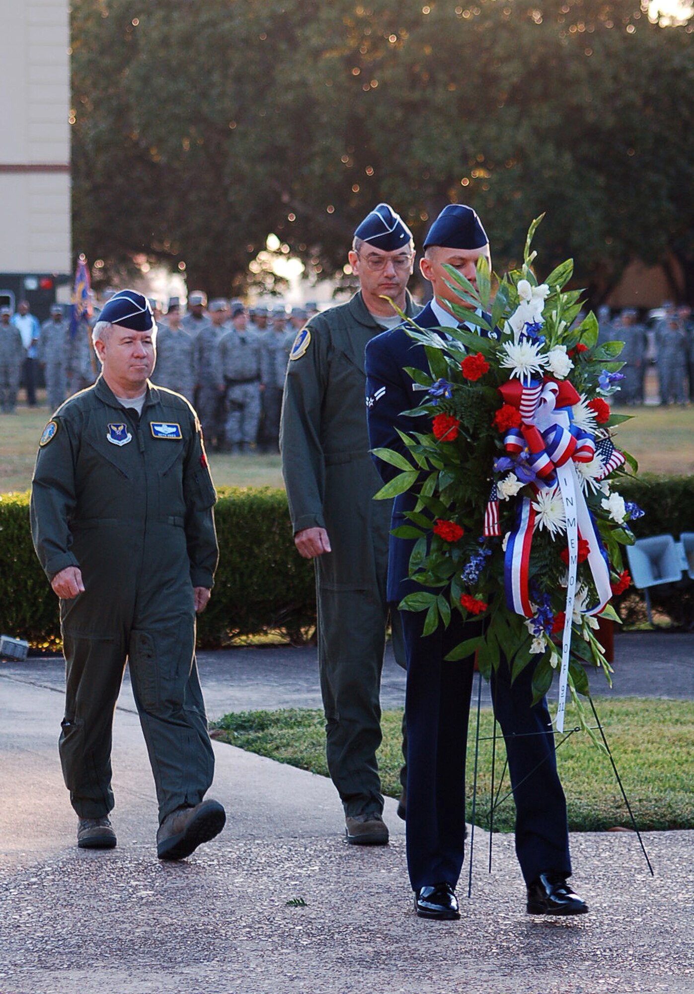 BARKSDALE AIR FORCE BASE, La. – Brig. Gens. Keith Kries, mobilization assistant to the Eighth Air Force commander, and John Mooney III, 307th Bomb Wing commander, walk to place a memorial wreath at the base of the 2nd Bomb Wing Headquarters flag pole during a 9/11 Reveille and Wreath Laying Ceremony on Barksdale Air Force Base Sept. 9, 2011. The ceremony included a moment of silence, which allowed Barksdale Airmen to reflect upon the tragic losses of Sept. 11, 2001, as well as the service and sacrifices made combating terrorism since that fateful day. (U.S. Air Force photo by Maj. Richard Komurek)