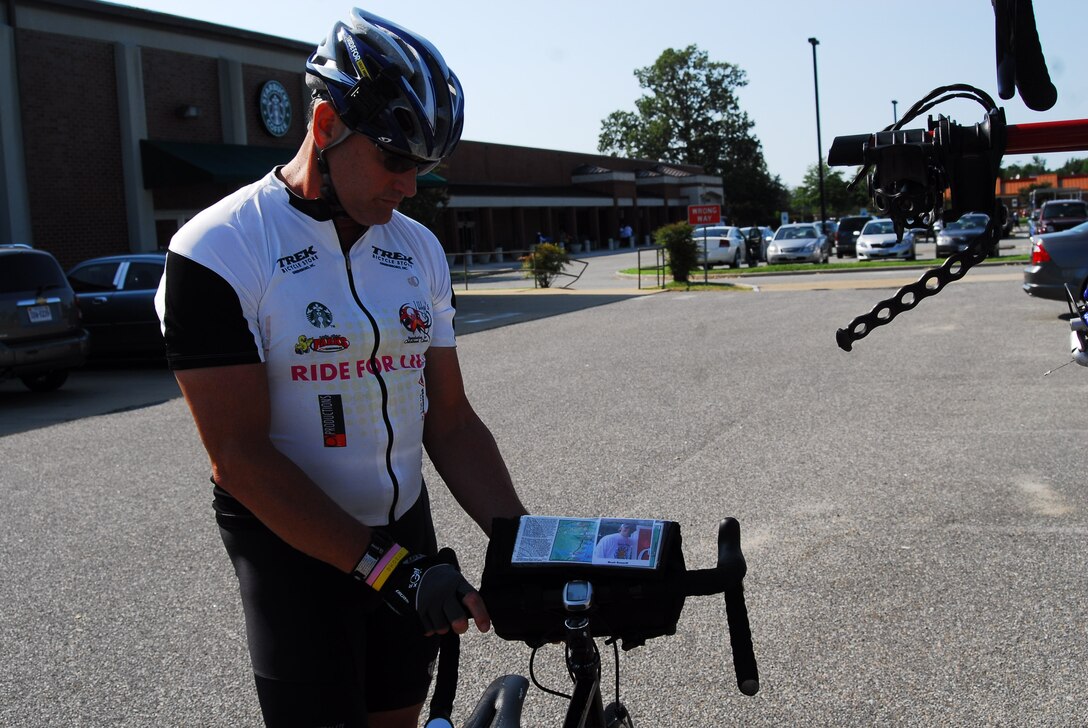 Mark Davis looks at the photo and bio of Brett Gosnell, 20, on his bicycle before beginning a portion of his ride at Fort Eustis Aug. 30. Gosnell died in 2006 of rhabdomyosarcoma, a form of muscle cancer, and is part of Davis' Chain of Children. (Photo by Monica Miller Rodgers/Released)