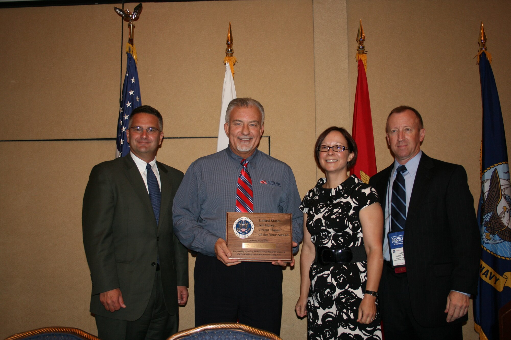 Michael L. Chase, second from left. Kirtland Federal Credit Union Board of Directors chairman, and Judy Ruiz, second from right, KFCU assistant vice president for public relations, receive a plaque naming KFCU the Air Force Credit Union of the Year for 2010 from Douglas Bennett, left, Associate Deputy Assistant Secretary of the Air Force for financial operations and James Sisson, right, Secretary for the Air Force director for financial operations.