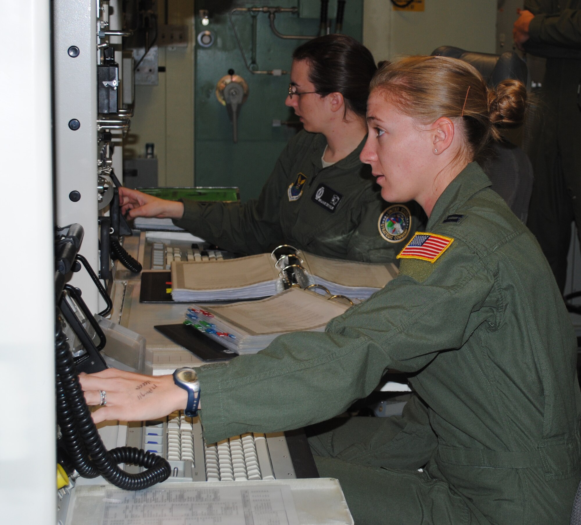 Capt. Megan Steele (front) and 2nd Lt. Brianne Seymour practice scenarios in the missile procedures trainer in preparation for the upcoming Global Strike Challenge competition Sept. 12-16.  The two were selected to represent the 10th Missile Squadron. (U.S. Air Force photo/Airman 1st Class Katrina Heikkinen)