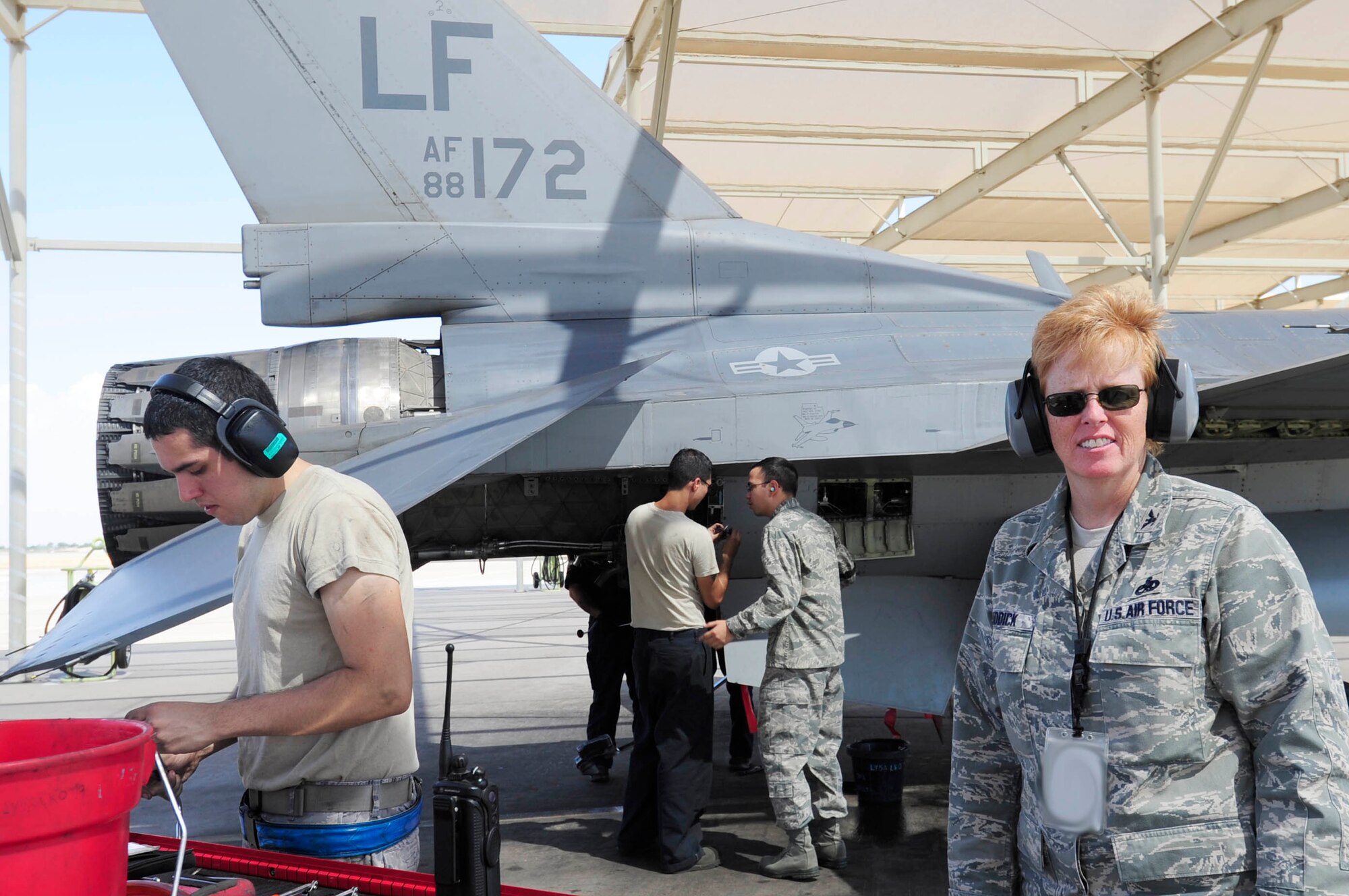 Col. Deborah Liddick, 56th Maintenance Group commander, visits the flightline as Airman 1st Class Kyle Goldfarb, Staff Sgt. Eric Conway, and 1st Lt. Charles Glover, 309th Aircraft Maintenance Unit, work on a F-16 Fighting Falcon Aug. 31.  (U.S. Air Force photo by Senior Airman Ronifel Yasay)