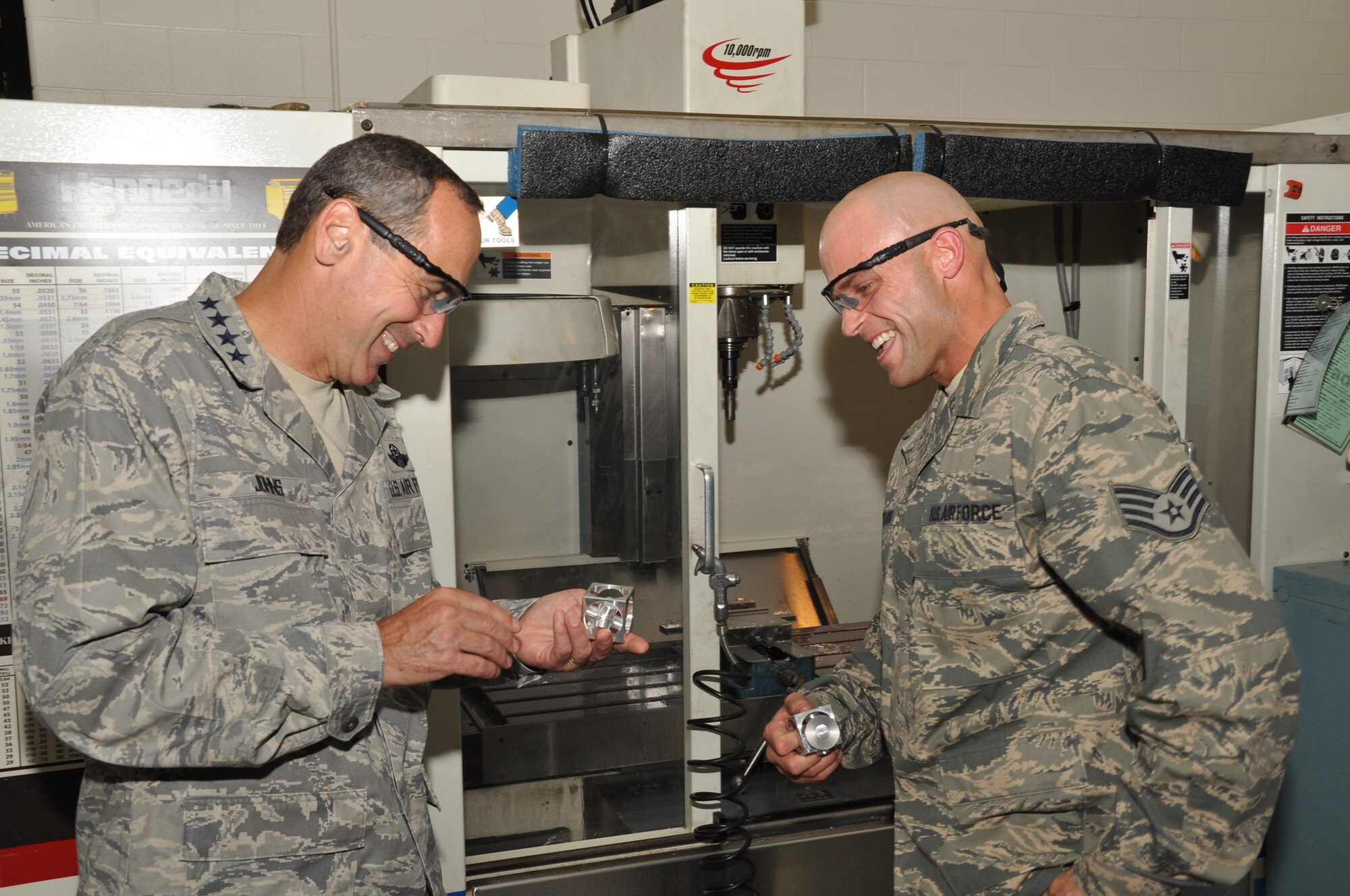 WRIGHT-PATTERSON AIR FORCE BASE, Ohio - Gen. Raymond E. Johns, Jr., commander, Air Mobility Command, is presented a "jack in the box" by Staff Sgt. Eric Whiteaker, 445th Maintenance Squadron aircraft metal technician, during the general's visit to the wing Aug. 6. Whiteaker used a milling machine to make the device. The milling machine is used to fabricate aircraft parts. (U.S. Air Force photo/Senior Airman Mikhail Berlin)