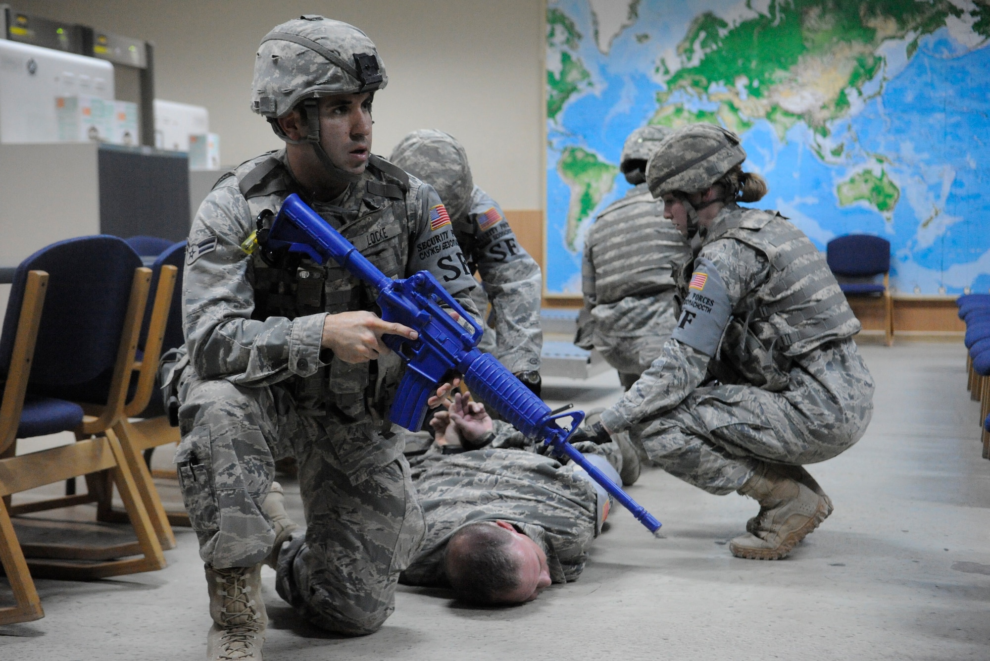 Airman 1st Class Jeffrey Locke stands watch to ensure his fellow defenders remain secure as they search Master Sgt. Donald Tipton, an active shooter role-player, for extra weapons during a training exercise at the Transit Center at Manas, Kyrgyzstan, Sept. 8. Locke and Tipton are members of the 376th Expeditionary Security Forces Squadron. Locke is a patrolman deployed here from Cheyenne Mountain, Colo. Tipton is a logistics superintendent deployed here from McConnell Air Force Base, Kan. (U.S. Air Force photo/Tech. Sgt. Tammie Moore)