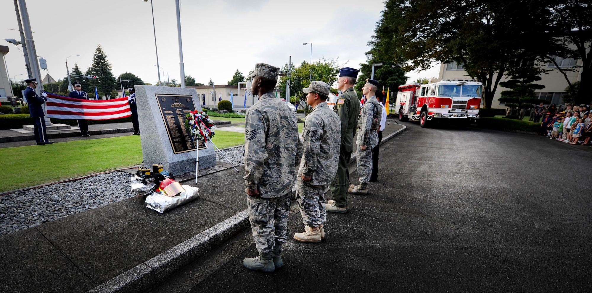 YOKOTA AIR BASE, Japan  -- Col. Otto Feather, 374th Airlift Wing commander, and  Airmen at Yokota Air Base, Japan, look on as members of the base honor guard retire the colors during the  9/11 retreat ceremony on Sept. 09, 2011. The ceremony acknowledged the courageous first responders and others who risked their lives to save the victims of Sept. 11, 2001, and service members who have joined the military since these events. (U.S. Air Force photo/Staff Sgt Stacy Moless)