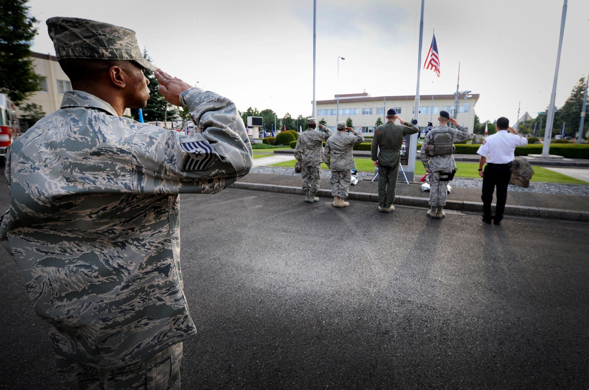 YOKOTA AIR BASE, Japan  -- Airmen at Yokota Air Base, Japan, look on as members of the base honor guard retire the colors during the  9/11 retreat ceremony on Sept. 09, 2011. The ceremony acknowledged the courageous first responders and others who risked their lives to save the victims of Sept. 11, 2001, and service members who have joined the military since these events. (U.S. Air Force photo/Staff Sgt Stacy Moless)