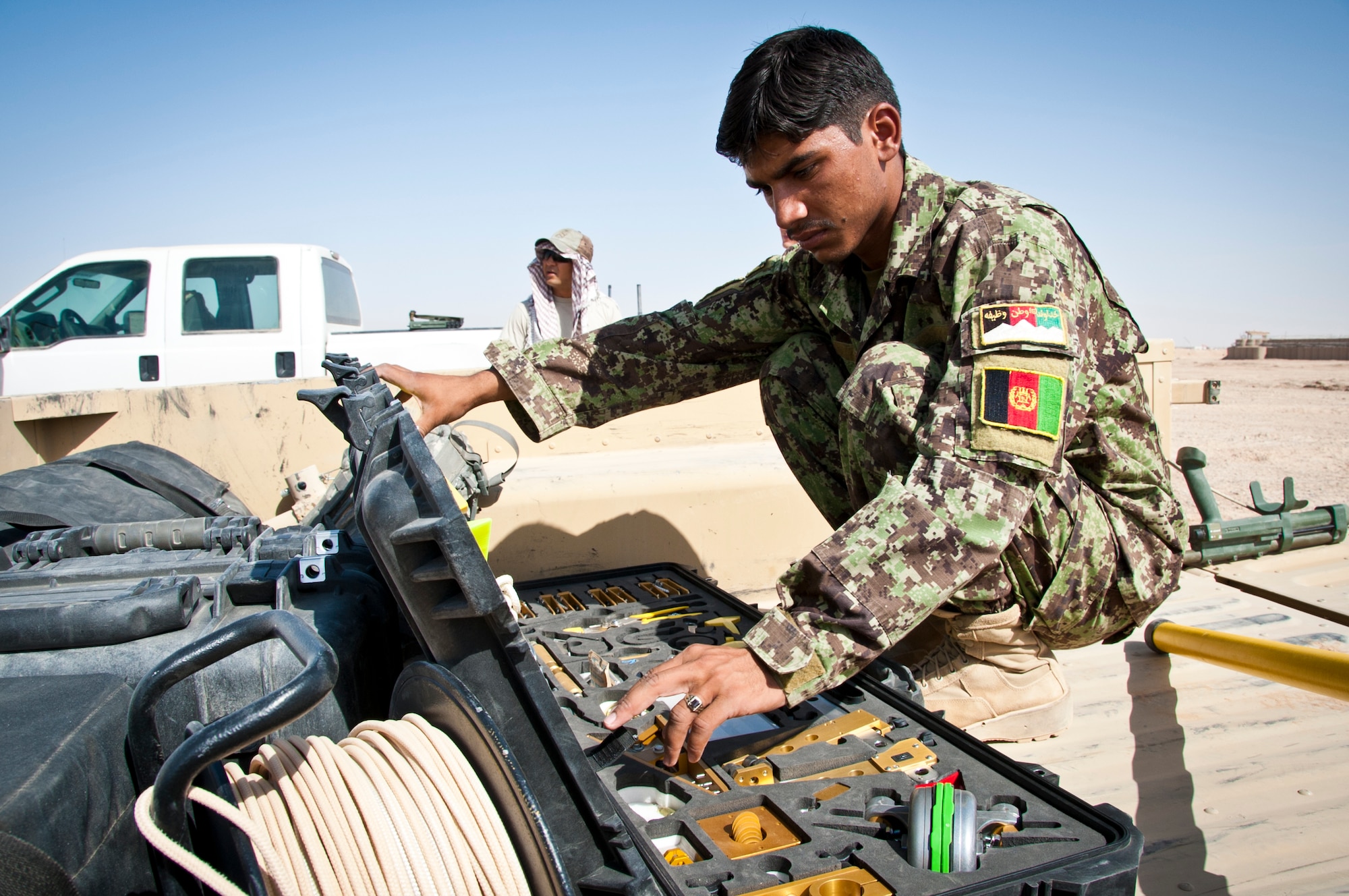 CAMP DWYER, Afghanistan -- A member of the Afghan National Army Explosive Ordnance Disposal team looks for a tool during a simulated improvise explosive device exercise at Camp Dwyer, Afghanistan, Sept. 4, 2011. The ANA will soon be validated by an Air Force EOD team to verify their capabilities in countering IEDs. (U.S. Air Force photo by Senior Airman David Carbajal)