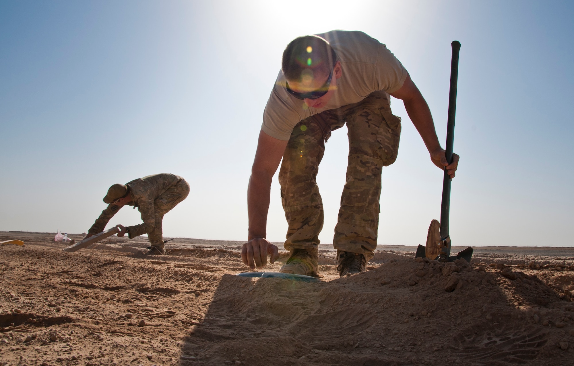 CAMP DWYER, Afghanistan -- Senior Airman Kristin Ponce (right) and Senior Airman Nikolas Cox dig out areas for simulated improvised explosive devices on a closed field course at Camp Dwyer, Afghanistan, Sept. 4, 2011. Ponce and Cox are members of the 466th Air Expeditionary Squadron Explosive Ordnance Disposal charlie flight who is training the Afghan National Army on the most current counter-IED procedures. (U.S. Air Force photo by Senior Airman David Carbajal)