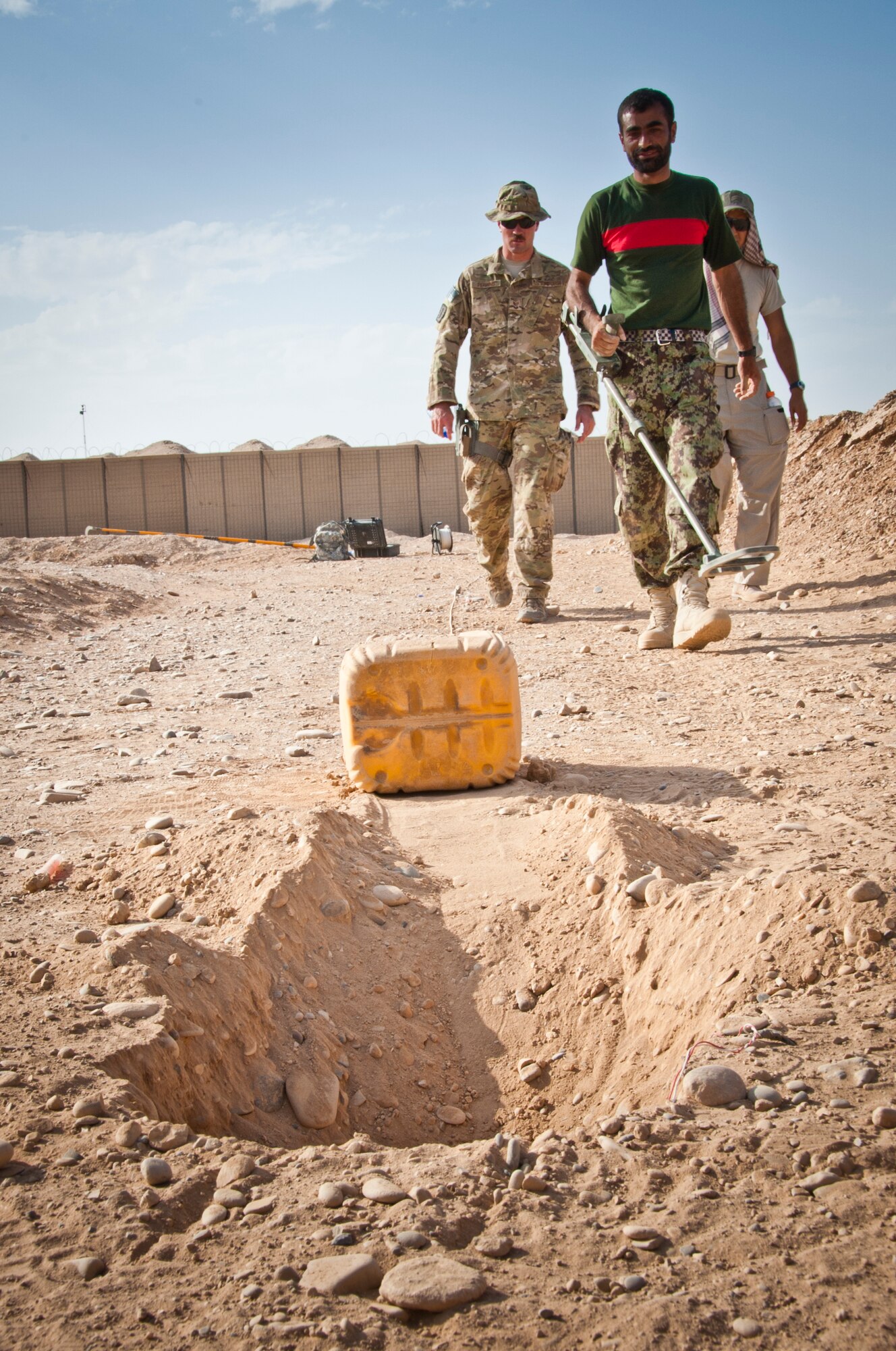 CAMP DWYER, Afghanistan -- An Afghan National Army Explosive Ordnance Disposal team leader walks up to a simulated improvised explosive device on a field-training course at Camp Dwyer, Afghanistan, Sept. 3, 2011. This simulation was a part of the validation process for the ANA EOD team to confirm their EOD capabilities. (U.S. Air Force photo by Senior Airman David Carbajal)