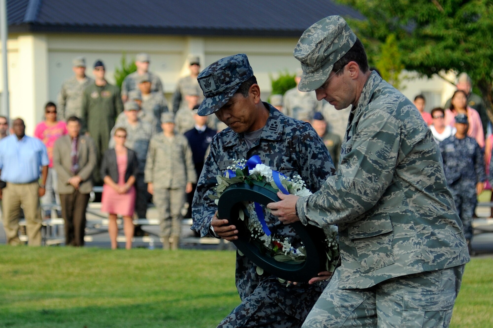 MISAWA AIR BASE, Japan – Japan Air Self-Defense Force Col. Yasuhisa Takada, left, 3rd Air Wing vice commander, and U.S. Air Force Col. Michael D. Rothstein, right, 35th Fighter Wing commander, place a commemorative wreath  during the Patriot Day ceremony at the base flag pole here Sept. 9. The ceremony served as a time to honor the victims and first responders in the 9/11 terrorist attacks. (U.S. Air Force photo/Tech. Sgt. Marie Brown)