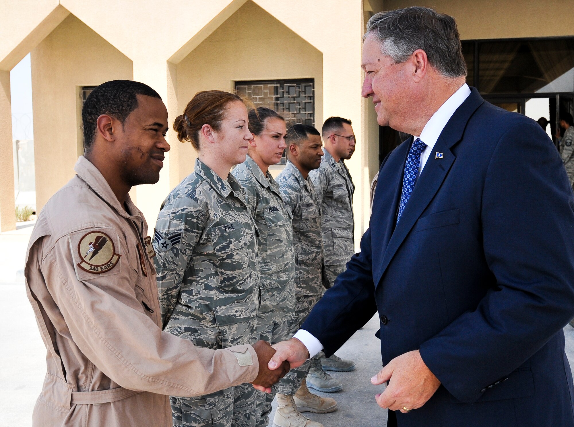 Secretary of the Air Force Michael Donley presents a coin to Senior Airman Robert White, 379th Expeditionary Air Refueling Squadron assistant boom operator, Sept. 8, 2011, at an undisclosed location in Southwest Asia.  During his visit, Donley addressed various issues affecting Air Force members such as retirement benefits, manning levels and counterinsurgency operations. (U.S. Air Force photo/Senior Airman Paul Labbe)