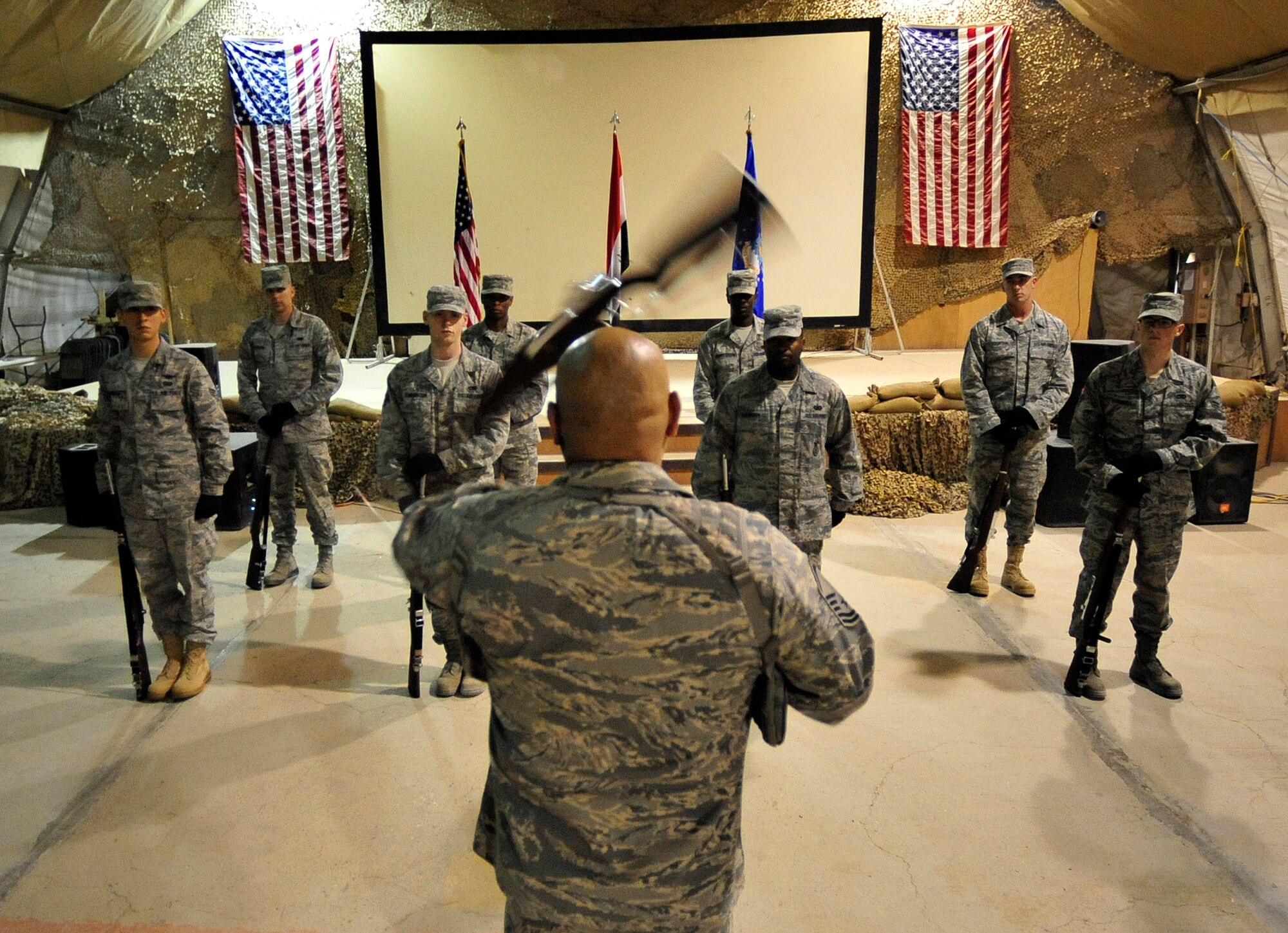 Master Sgt. Herman Ybarra demonstrates drill team techniques Aug. 28, 2011, to his 407th Air Expeditionary Group Honor Guard in preparation for their 9/11 ceremony at Ali Base, Iraq.  Sergeant Ybarra is deployed from Vandenberg Air Force Base, Calif., and is a native of Corpus Christi, Texas. (U.S. Air Force photo/Master Sgt. Cecilio Ricardo)