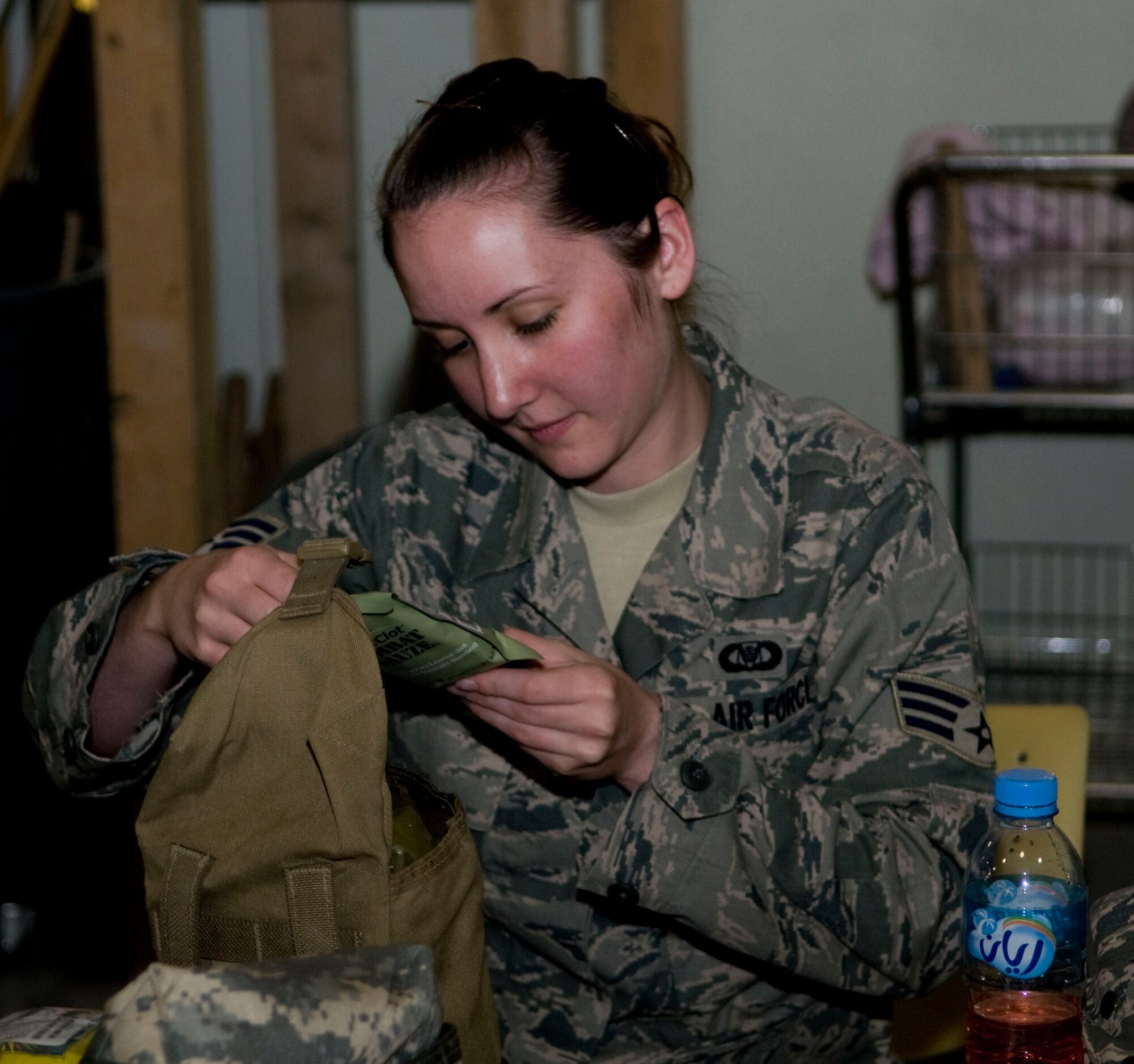 Senior Airman Mindy Tate, a volunteer from the 379th Expeditionary Operations Support Squadron, checks the expiration date on a package of combat gauze during a mass individual first aid kit rebuild, Aug. 24.  Tate is deployed from Travis Air Force Base, Calif. (U.S. Air Force photo/Senior Airman Eric Summers Jr.)