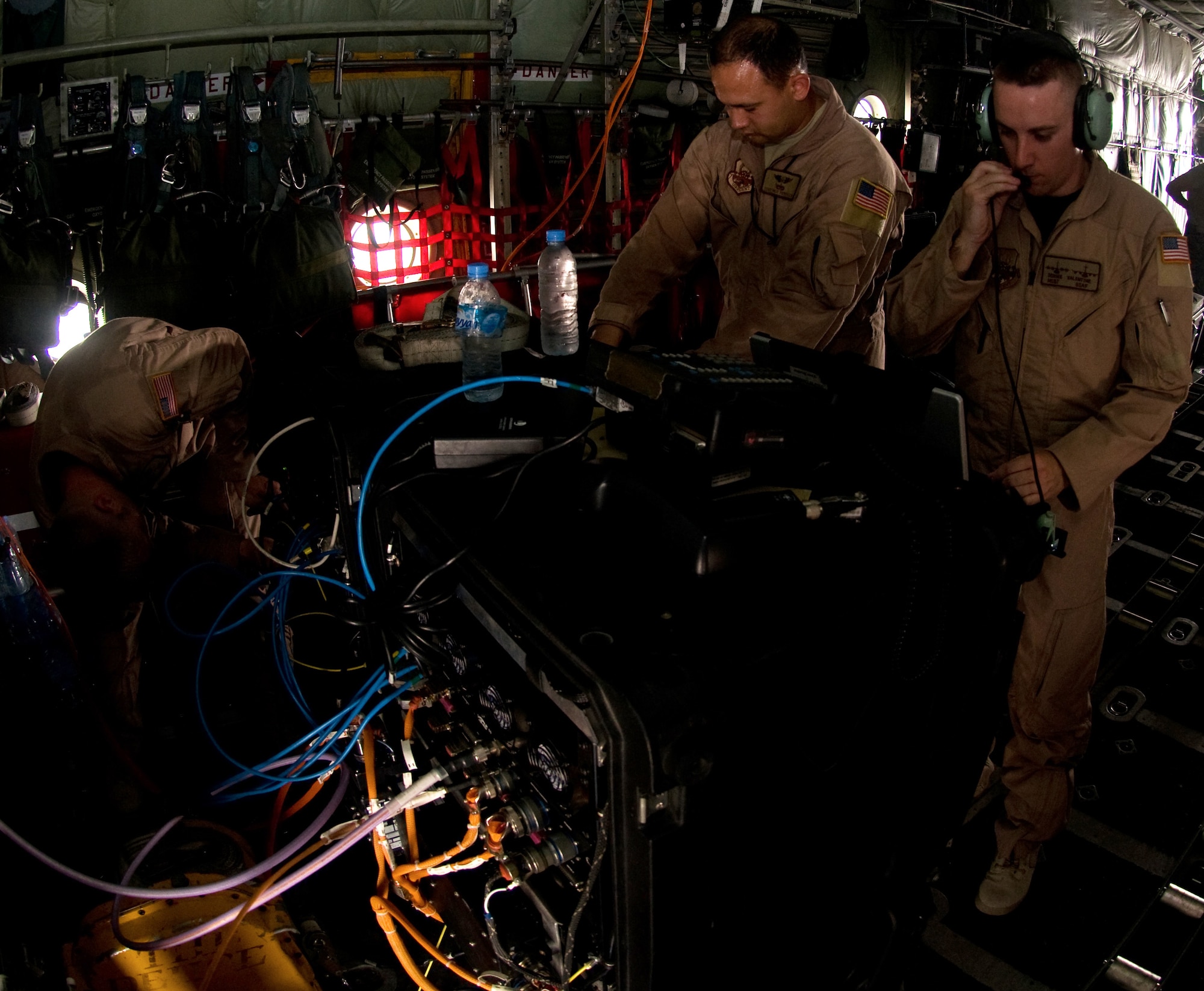 (From left) Tech. Sgt. Rocky Laprade, Staff Sgt. Ron Peterson, and Master Sgt. Donnie Valentine, 379th Expeditionary Communications Squadron viper team members, run tests on a communications system they set up on a C-130 Hercules, Aug. 26. (U.S. Air Force photo/Senior Airman Eric Summers Jr.)