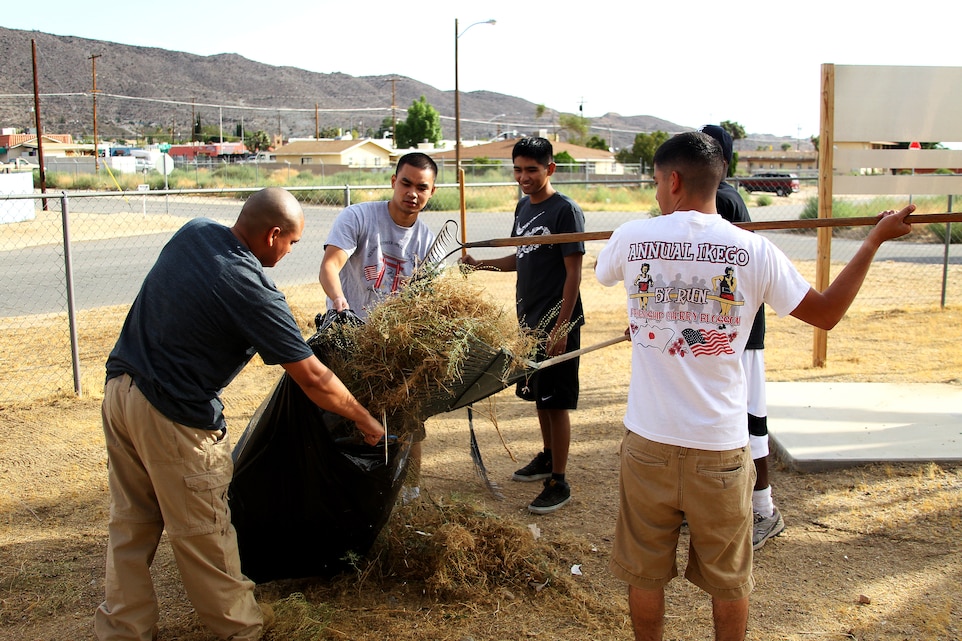 Dental and hospital corpsmen with the Combat Center dispose of weeds at the Veterans of Foreign Wars Post 9431 yard Sept. 10, 2011, to prevent fire safety hazards.