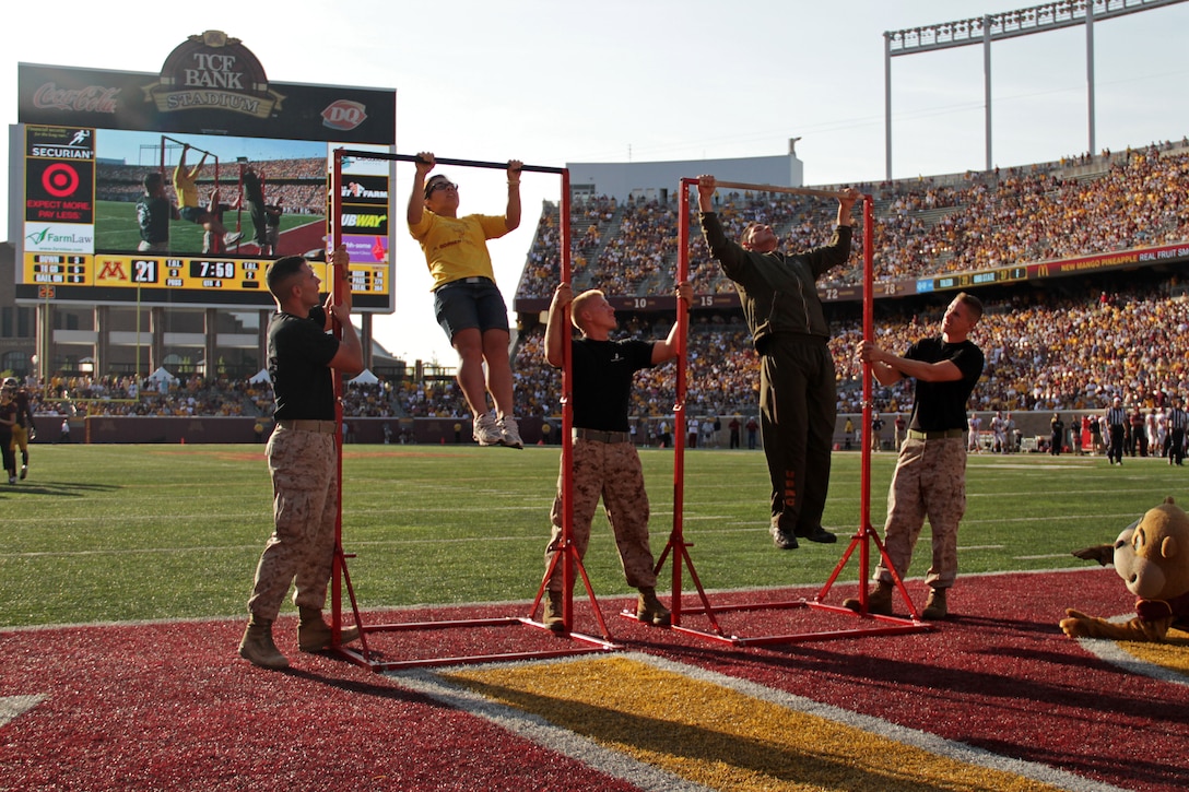 Marine recruiter Sgt. Timothy Riffe competed in a pull-up challenge against University of Minnesota gymnast Justine Cherwink at TCF Bank Stadium for the Military Appreciation Football Game Sept. 10. During a time-out in the fourth quarter, Riffe and Cherwink had 30 seconds to complete as many pull-ups as possible. More than 48,800 Golden Gopher fans cheered as Cherwink knocked out 18. However, it wasn't enough to beat Riffe who completed 28. For additional imagery from the event, visit www.facebook.com/rstwincities.
