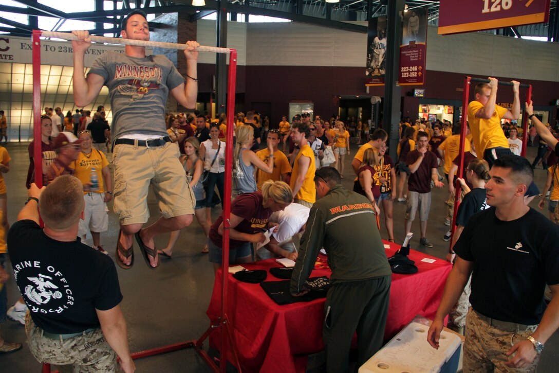 Marine officer candidates and recruiters motivate college students to take the pull-up or flexed-arm hang challenge at TCF Bank Stadium Sept. 10. Three Marine lieutenants from Marine Corps Officer Selection Station Twins Cities reaffirmed their oath of office during the Minnesota Gophers halftime show. For additional imagery from the event, visit www.facebook.com/rstwincities.