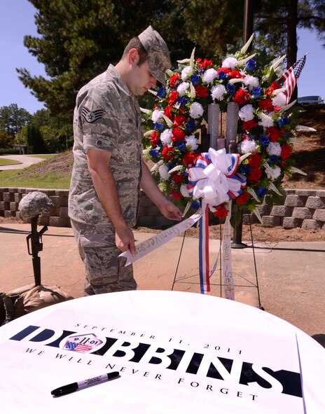 Staff Sgt. Shaun Shenk, 94th Airlift Wing Public Affairs, puts the finishing touches on a 9/11 memorial display set up at the Dobbins Air Reserve Base POW/MIA memorial, Sept 10.  9/11 services will be held on Sunday to honor the tenth anniversary of the 2001 terrorist attacks. Visitors can sign a memorial poster throughout the day and attend a retreat ceremony at 3:45 PM   (U.S. Air Force photo/ Brad Fallin)