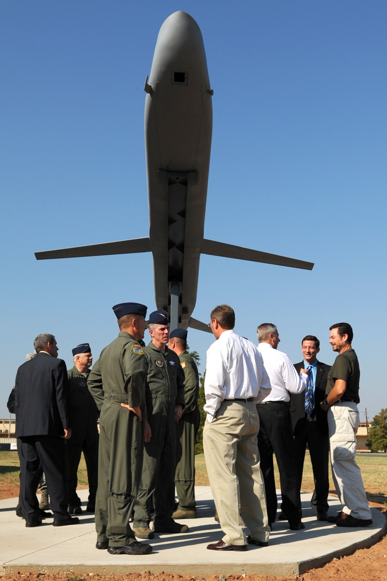 Past and present B-52 bomber aircrew members gather underneath a Conventional Air Launched Cruise Missile (CALCM) monument following its unveiling at Barksdale Air Force Base, La., Sept. 9, 2011. In 1991, many of the attendees participated in the longest combat mission in aviation history and the first combat launch of a CALCM during Operation Desert Storm. (U.S. Air Force photo by Master Sgt. Greg Steele/Released)