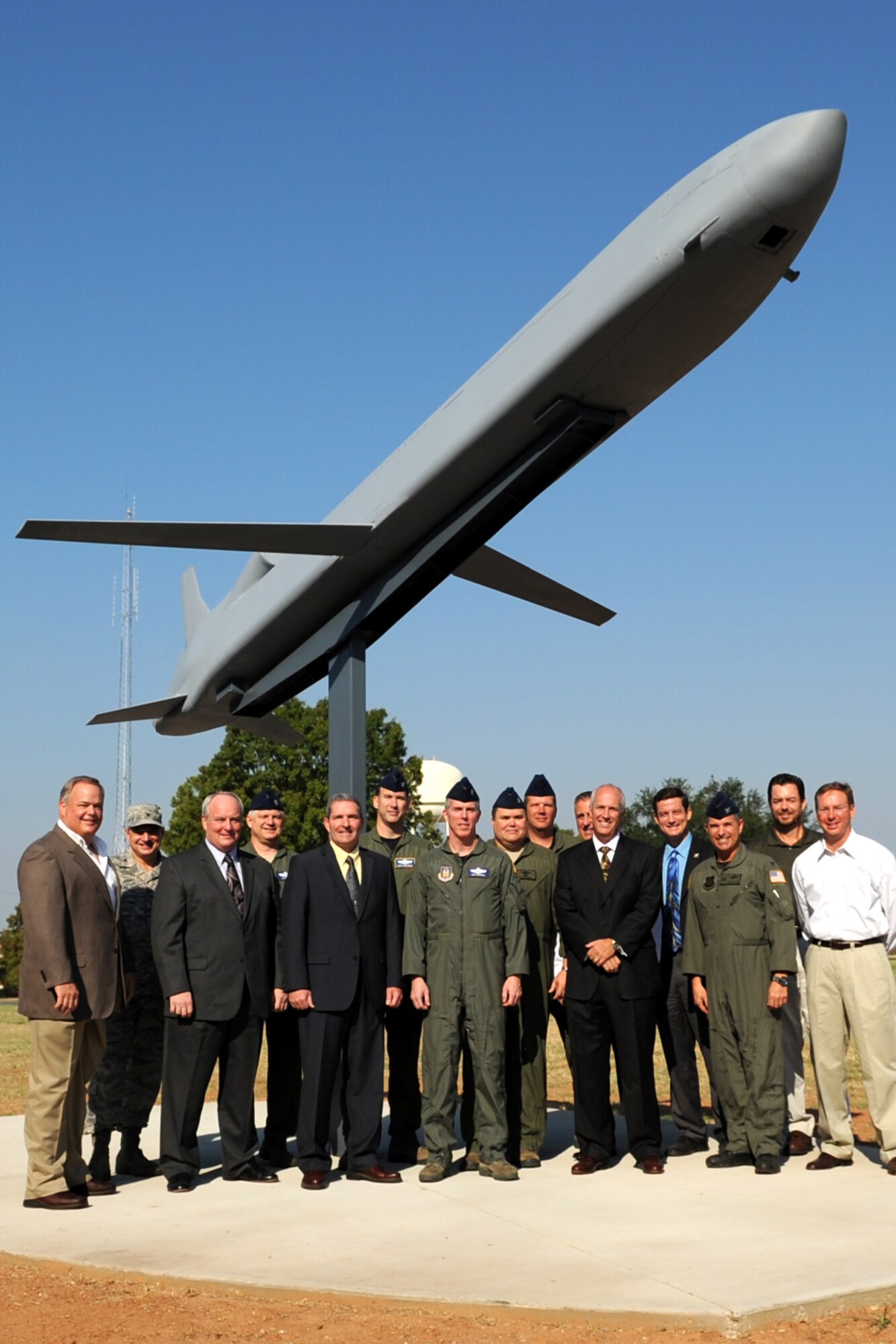 Past and present B-52 bomber aircrew members gather underneath a Conventional Air Launched Cruise Missile (CALCM) monument following its unveiling at Barksdale Air Force Base, La., Sept. 9, 2011. In 1991, many of the attendees participated in the longest combat mission in aviation history and the first combat launch of a CALCM during Operation Desert Storm. (U.S. Air Force photo by Master Sgt. Greg Steele/Released)