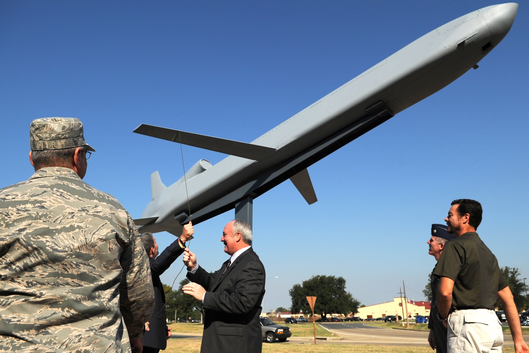 Former B-52 bomber aircrew members extend the wings of a Conventional Air Launched Cruise Missile (CALCM) following its unveiling at Barksdale Air Force Base, La., Sept. 9, 2011. The CALCM monument is dedicated to the weapons system and its history with the B-52. (U.S. Air Force photo by Master Sgt. Greg Steele/Released)