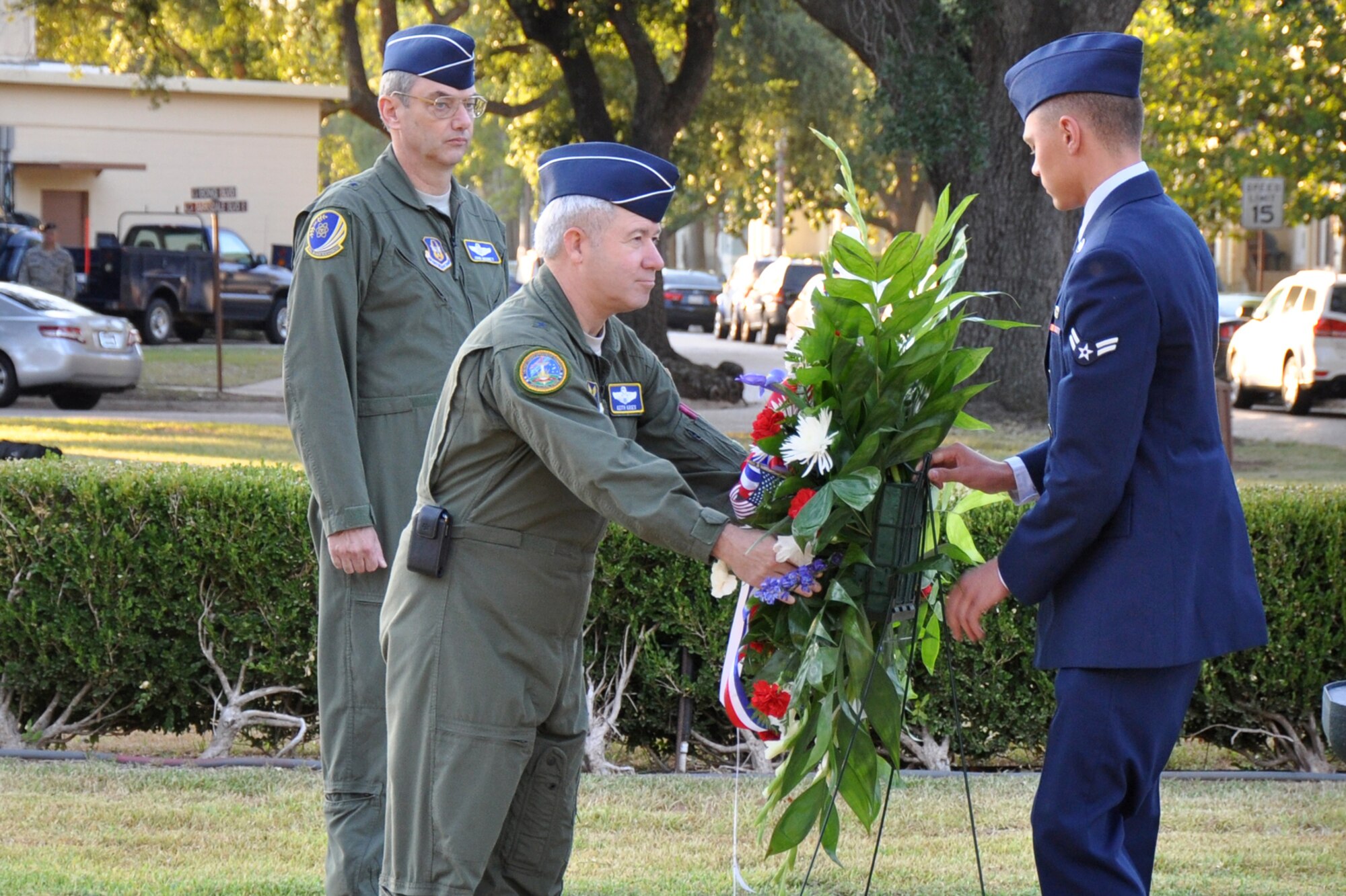 Brig. Gen. Keith Kries, the mobilization assistant to the Eighth Air Force commander, assists in the placing of flowers at the base of the flag pole in front of the 2nd Bomb Wing Headquarters building during the 9/11 Remembrance Ceremony at Barksdale Air Force Base, La., Sept. 9, 2011. The ceremony, which included the singing of the Star-Spangled Banner and the placing of the flowers, also included a moment of silence for reflection of the losses, both military and civilian since Sept. 11, 2001. (U.S. Air Force photo by Tech. Sgt. Jeff Walston/Released)