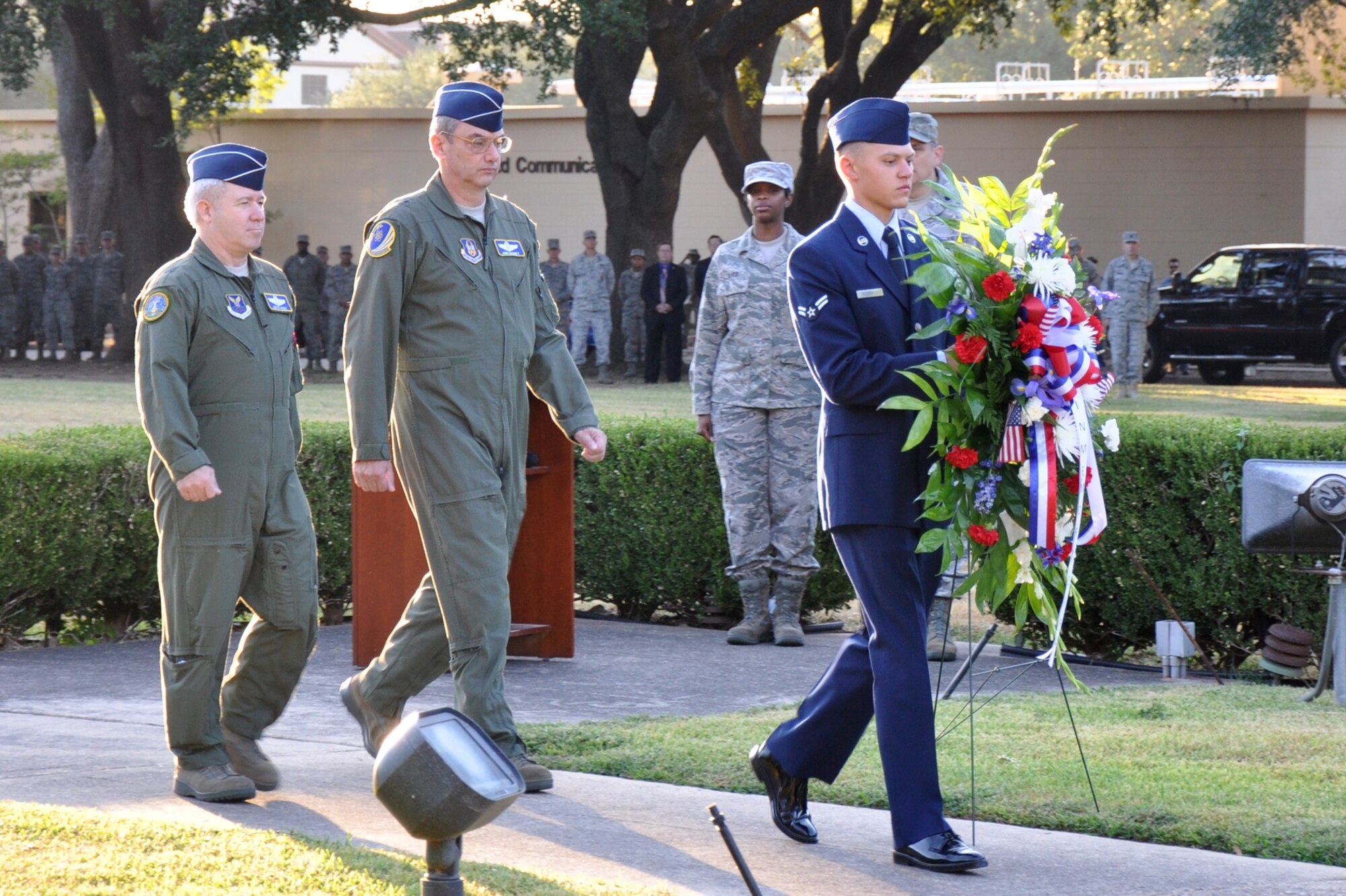 Brig. Gens. Keith Kries, the mobilization assistant to the Eighth Air Force commander and John J. Mooney III, the commander of the 307th Bomb Wing, walk to the flag pole in front of the 2nd Bomb Wing Headquarters building to place flowers during the 9/11 Remembrance Ceremony at Barksdale Air Force Base, La., Sept. 9, 2011. The ceremony, which included the singing of the Star-Spangled Banner and the placing of the flowers, also included a moment of silence for reflection of the losses, both military and civilian since Sept. 11, 2001. (U.S. Air Force photo by Tech. Sgt. Jeff Walston/Released)