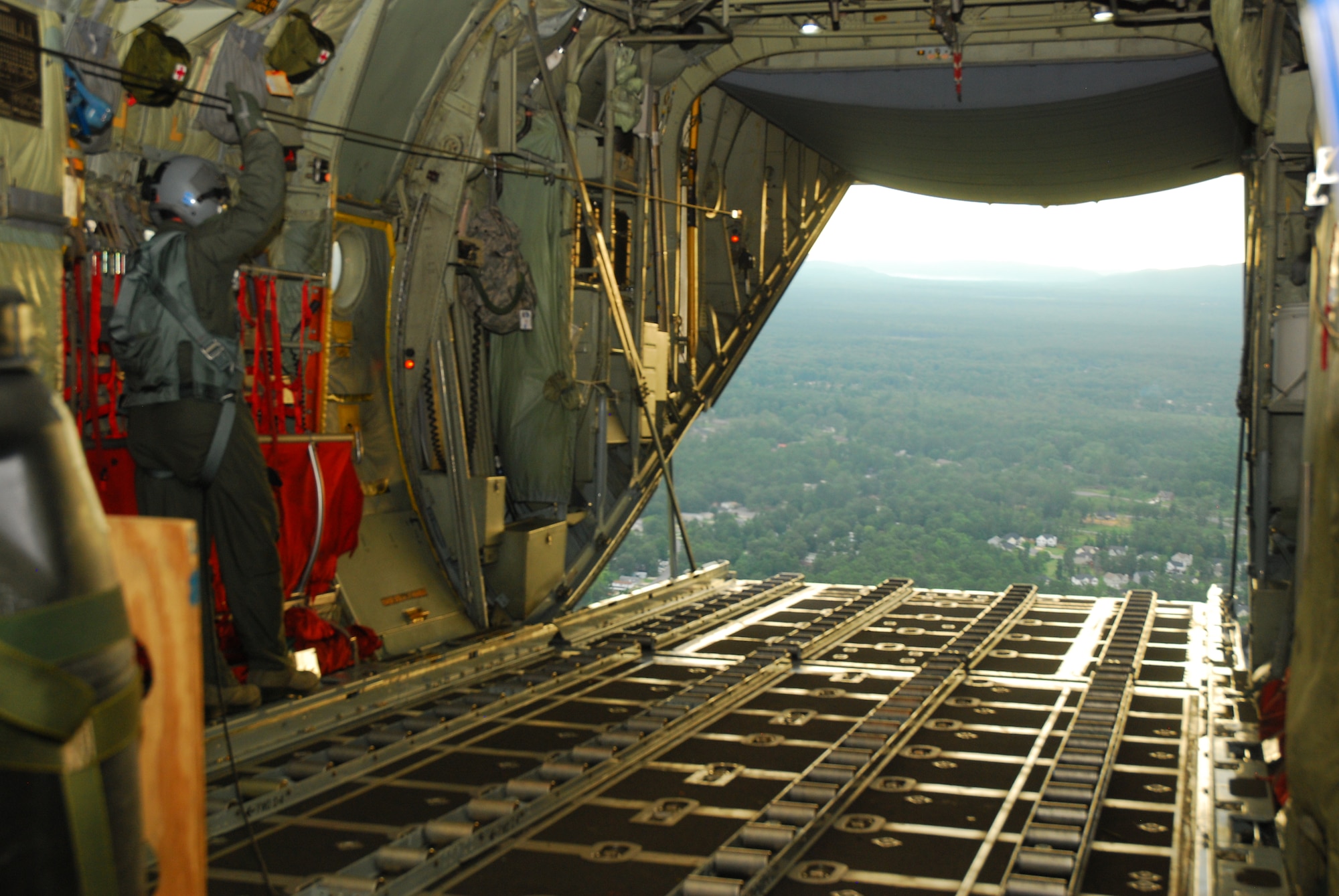 Andrew Powell, 700th Airlift Wing loadmaster, waits for the second bundle of consolidated delivery systems to be released from the C-130H aircraft on a training mission conducted Aug. 9. (U.S. Air Force photo/Airman 1st Class Chelsea Smith)