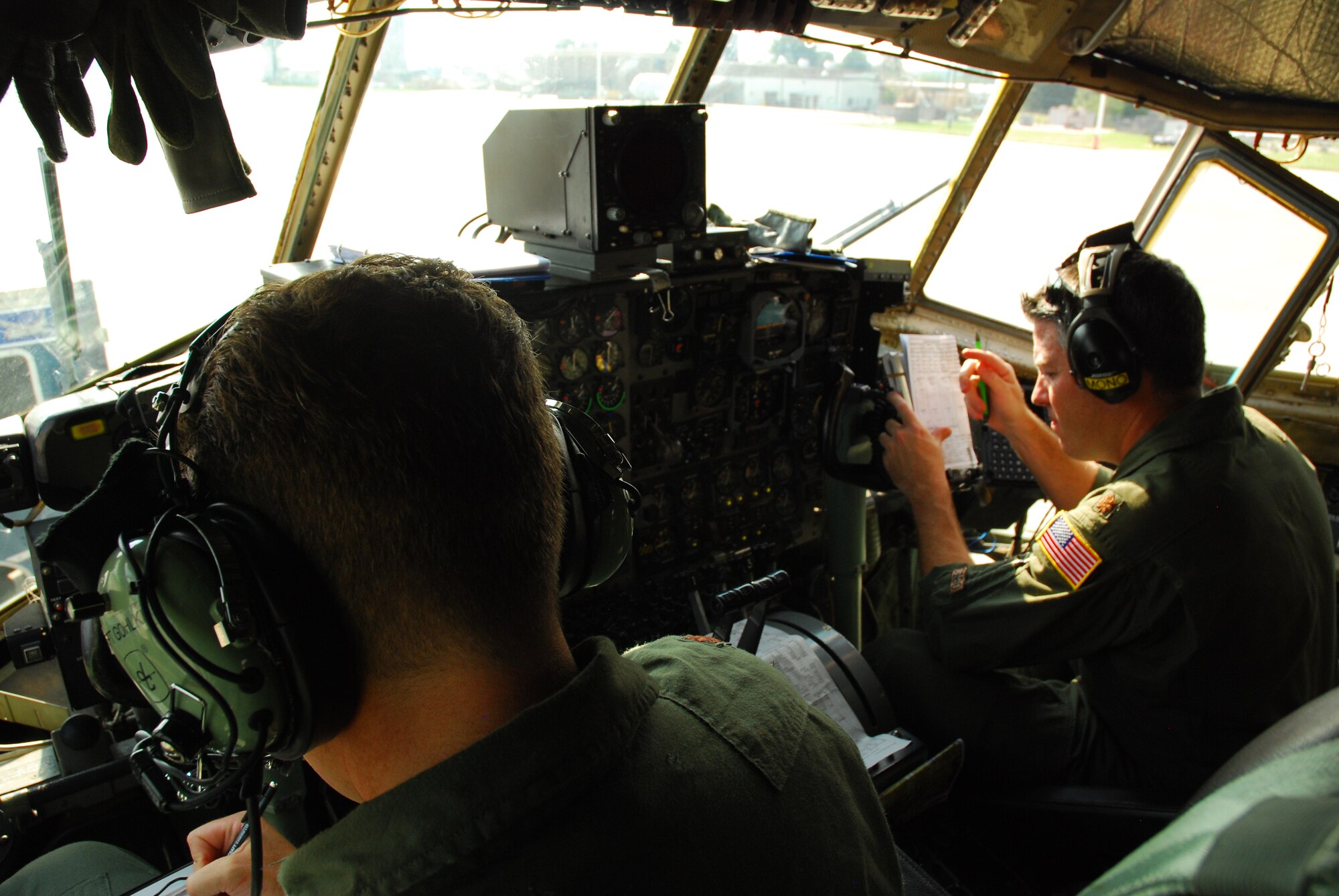Majs. John Monahan (left) and Chris Gohlke, 700th Airlift Squadron, perform pre-flight checks before a training mission held Aug 9. The Pilots performed six touch-and-go landings in the C-130 for currency training. (U.S. Air Force photo/Airman 1st Class Chelsea Smith)